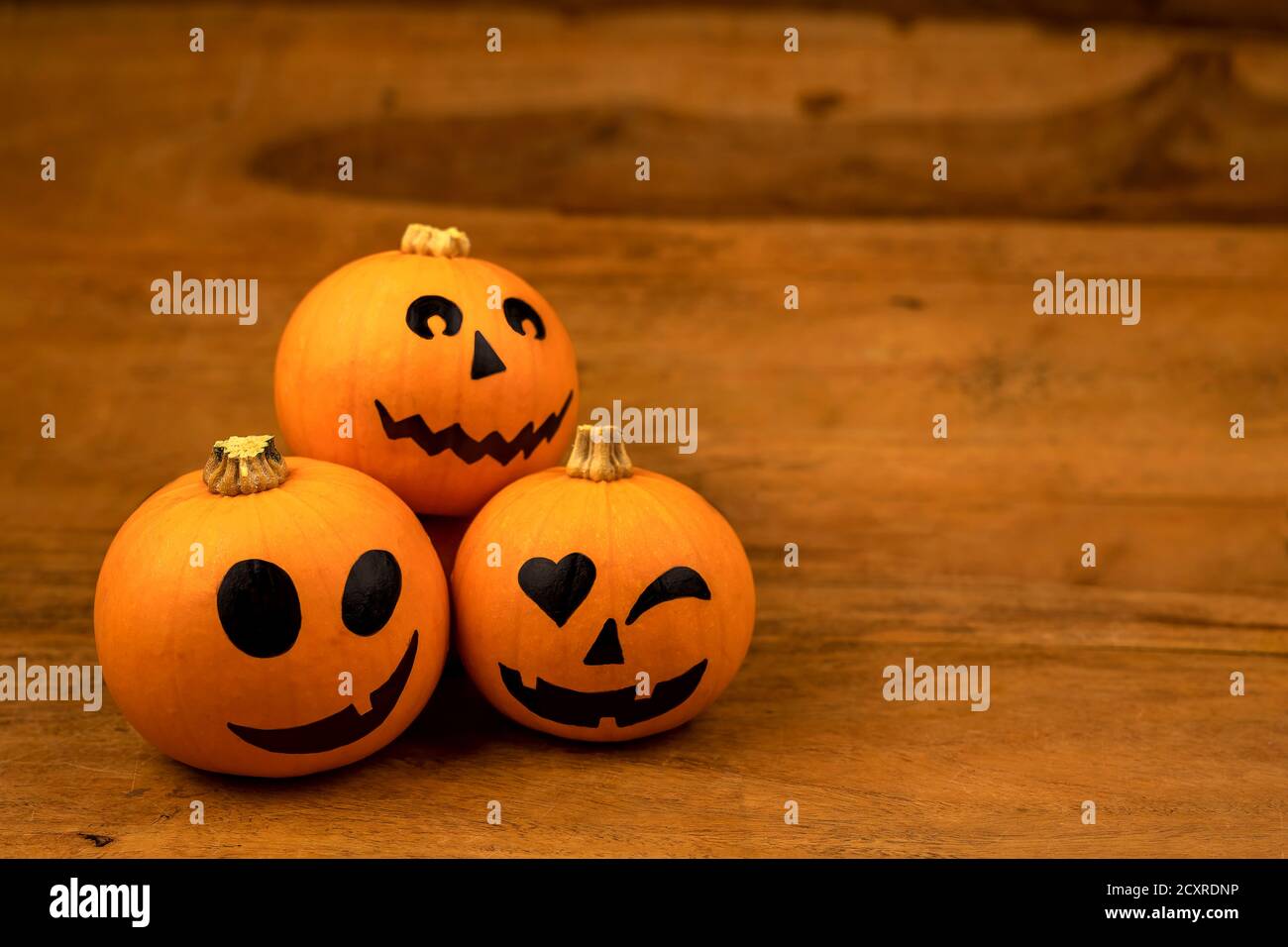 Zucche piccole con facce dipinte per Halloween su sfondo di legno Foto Stock