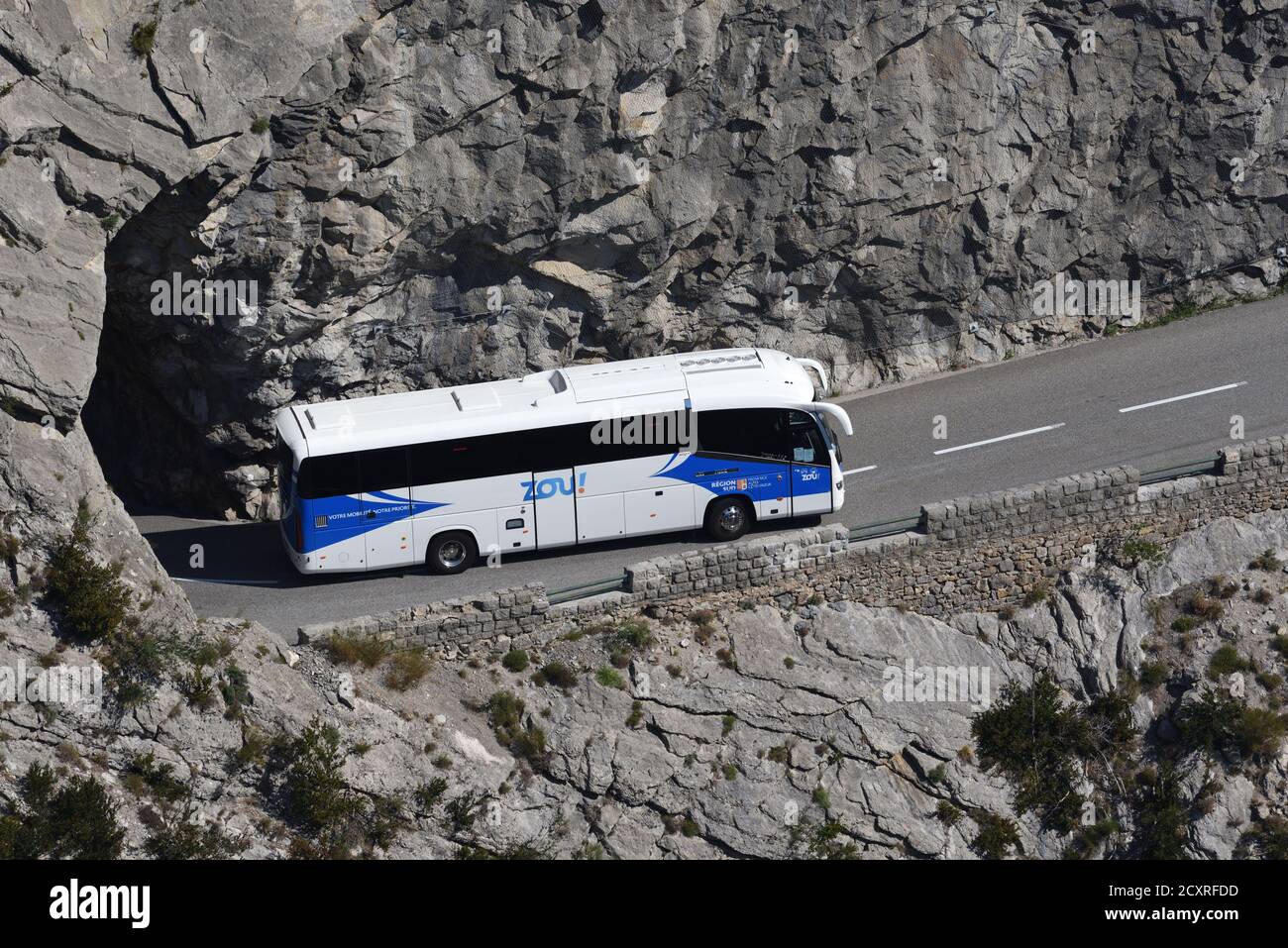 Autobus o pullman che guidano su strada stretta di montagna con pericoloso Scogliere nel indizio de Taulanne vicino Castellane Alpes-de-Haute-Provence Provenza Provenza Francia Foto Stock