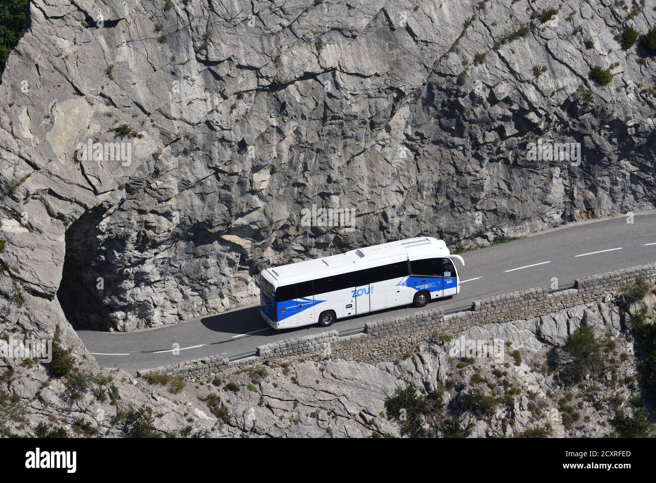 Autobus o pullman che guidano su strada stretta di montagna con pericoloso Scogliere nel indizio de Taulanne vicino Castellane Alpes-de-Haute-Provence Provenza Provenza Francia Foto Stock