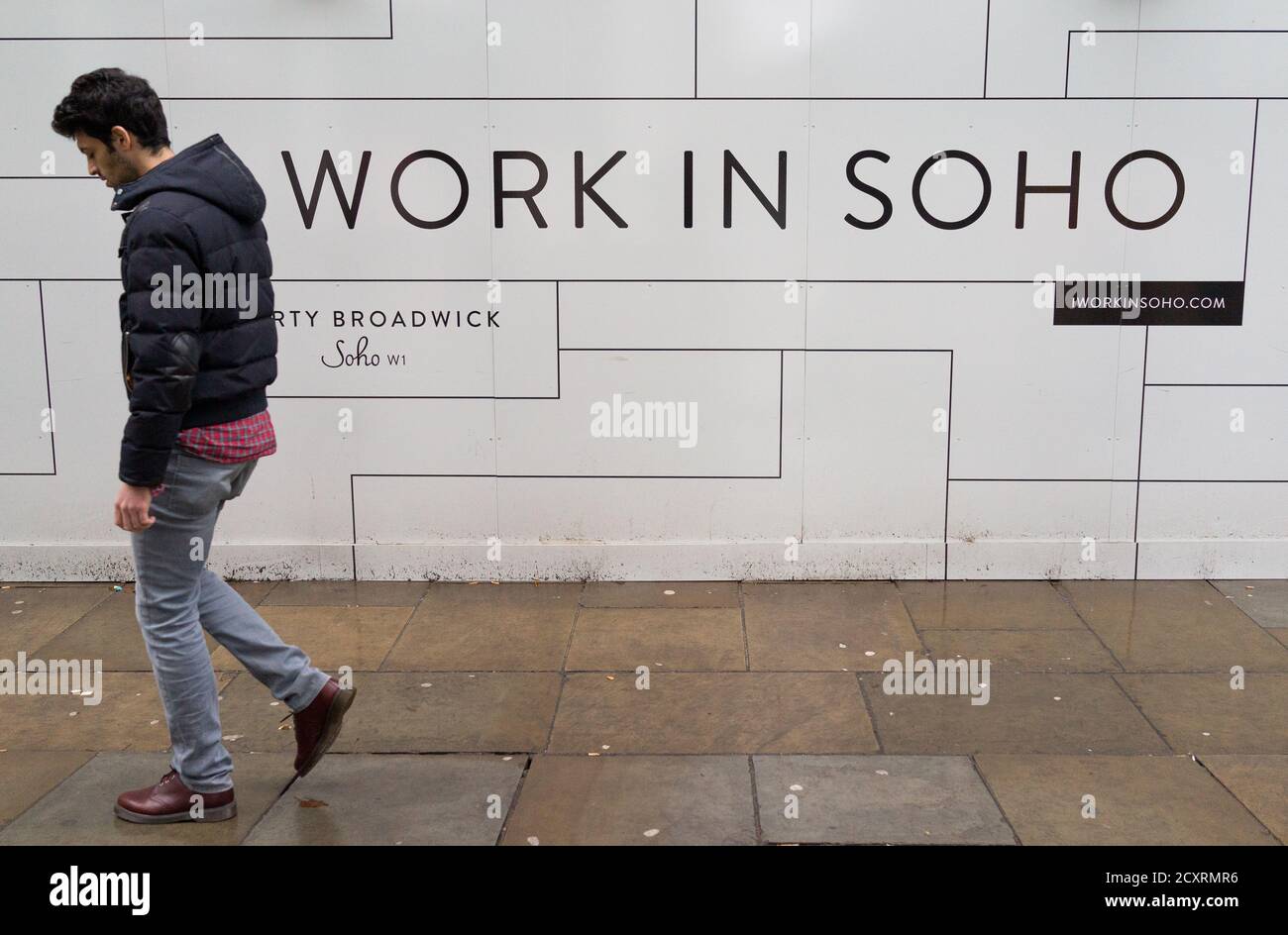 Un uomo cammina oltre un cartello che dice lavoro a soho su Broadwick Street. L’area di Soho del West End di Londra in un giorno freddo e umido di gennaio. 31 gennaio 2016. PH Foto Stock