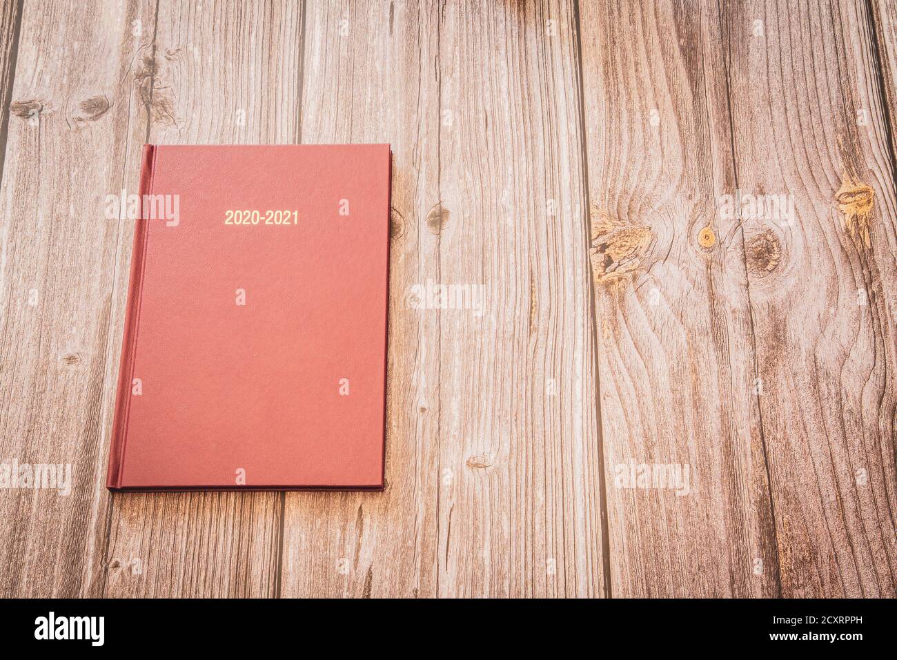 Un diario del 2020 e del 2021 poggiato su un legno rustico sfondo con spazio di copia Foto Stock