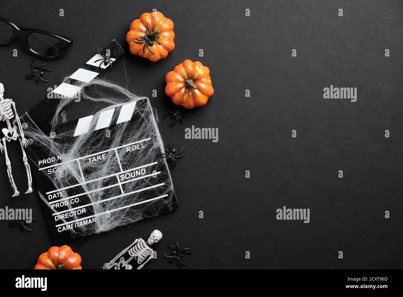 Clapperboard film e decorazione halloween su tavolo nero. Serata di film horror, invito alla festa di Halloween. Sfondo di Halloween Foto Stock
