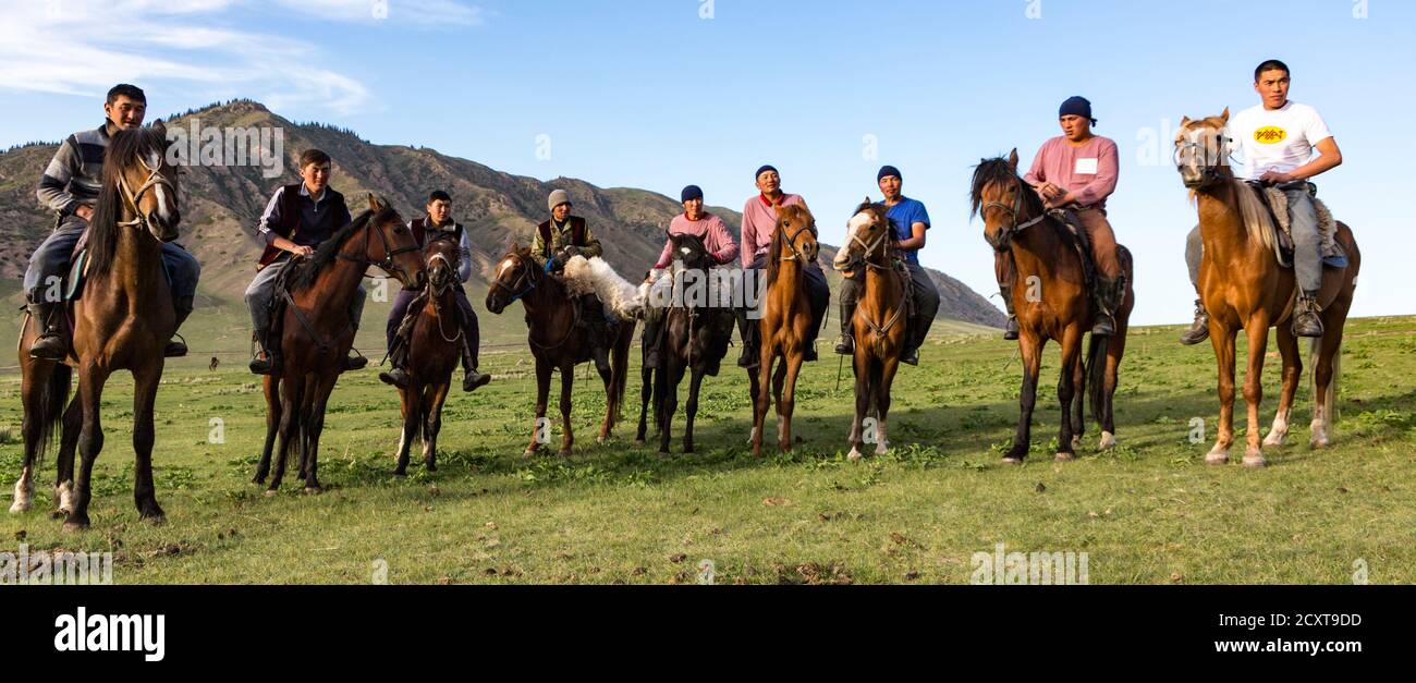 Issyk Kul, Kirghizistan - 28 Maggio 2017 - i giocatori Buzkashi line up prima del loro gioco in cui essi cercano di gettare una testa di capra in un anello di obiettivo Foto Stock