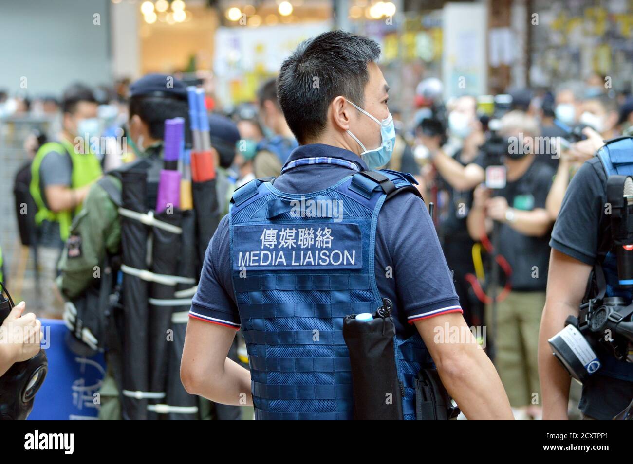 Un ufficiale di collegamento dei media della polizia di Hong Kong nel quartiere dello shopping di Causeway Bay il giorno nazionale, 1° ottobre 2020 Foto Stock
