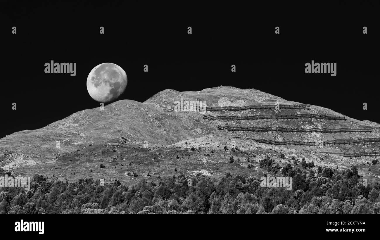 Spettacolare vista in bianco e nero sulla luna che si affaccia sul monte San Valentino alla Muta, Alto Adige, Italia Foto Stock
