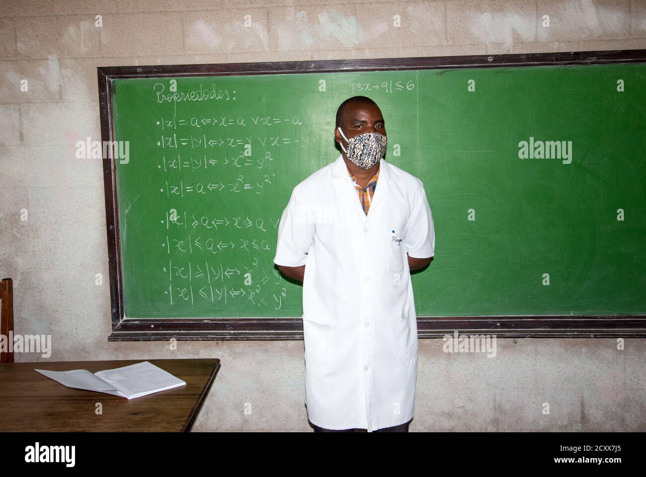 Insegnante che indossa la maschera in classe, nella nuova normalità, dopo l'interruzione causata da covid-19 Foto Stock
