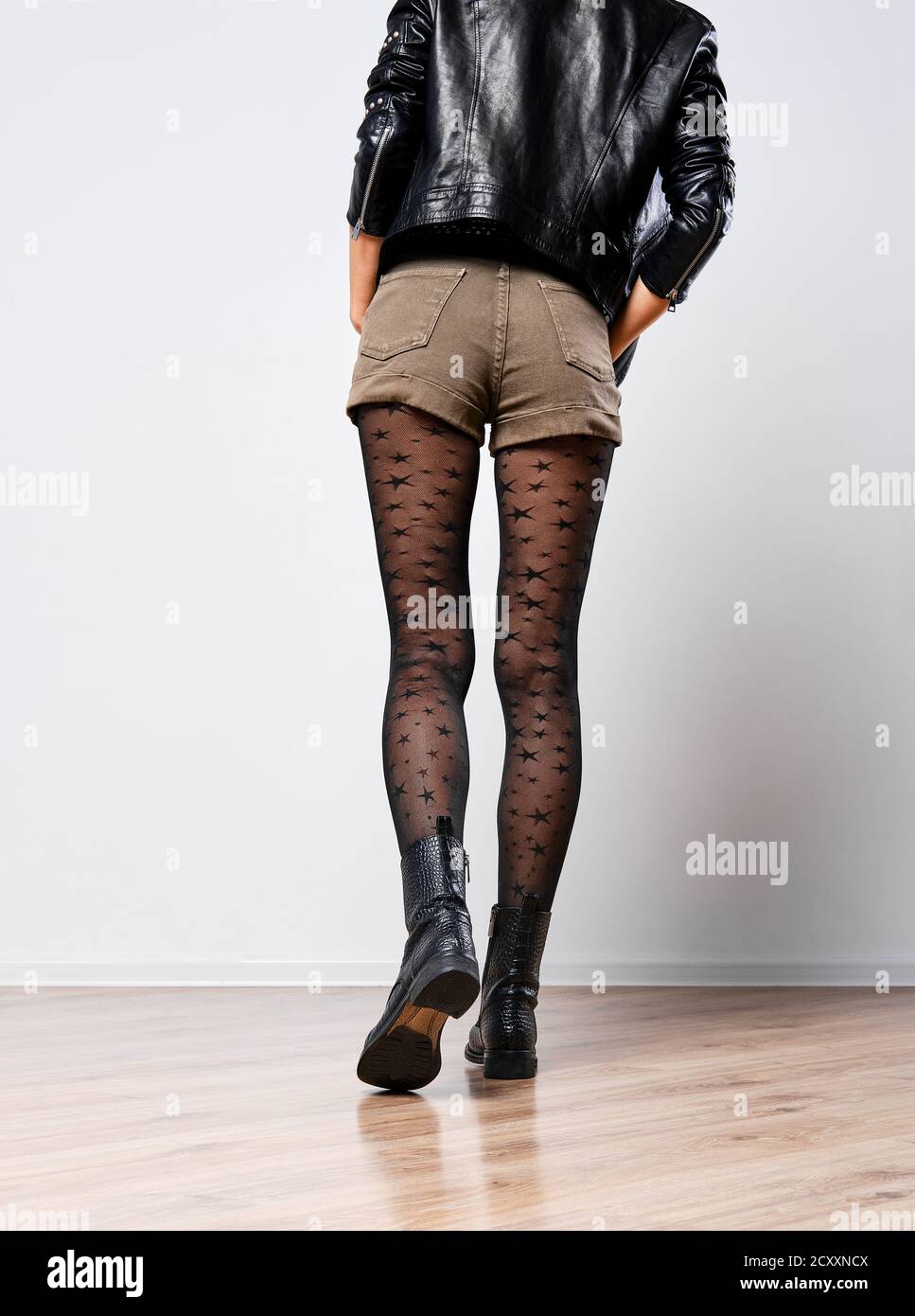 Vista posteriore delle gambe sottili femmina in collant nero con stelle Foto Stock