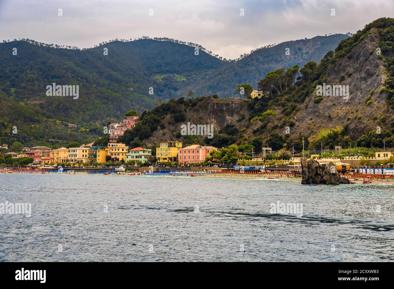 Splendida vista panoramica sulla spiaggia di sabbia, i colorati edifici, la famosa roccia dello Scoglio di Monterosso e le colline sullo sfondo di Fegina,... Foto Stock