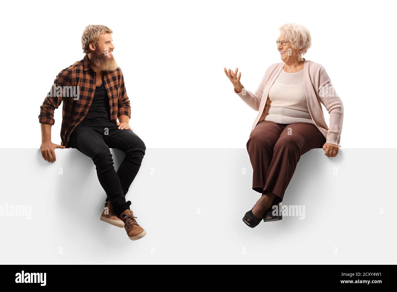 Giovane uomo bearded seduto su una tavola bianca e. ascolto di una donna anziana isolata su sfondo bianco Foto Stock