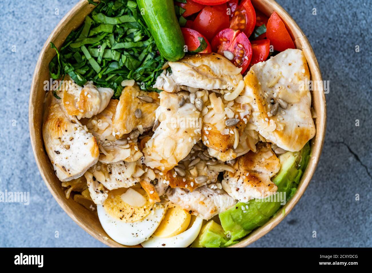 Sana Protein Fitness cibo Pollo, uovo, Spinach, avocado e cetriolo con attrezzature fitness Dumbbells per atleta in plastica Bowl. Pronto a mangiare. Foto Stock
