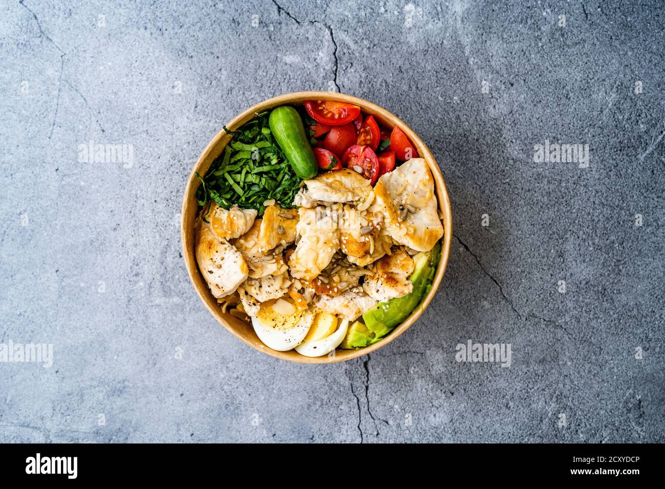 Sana Protein Fitness cibo Pollo, uovo, Spinach, avocado e cetriolo con attrezzature fitness Dumbbells per atleta in plastica Bowl. Pronto a mangiare. Foto Stock