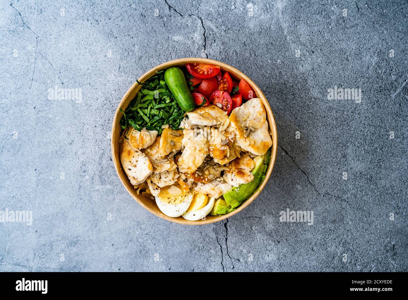 Sana Protein Fitness cibo Pollo, uovo, Spinach, avocado e cetriolo con attrezzature fitness Dumbbells per atleta in plastica Bowl. Pronto a mangiare. Foto Stock