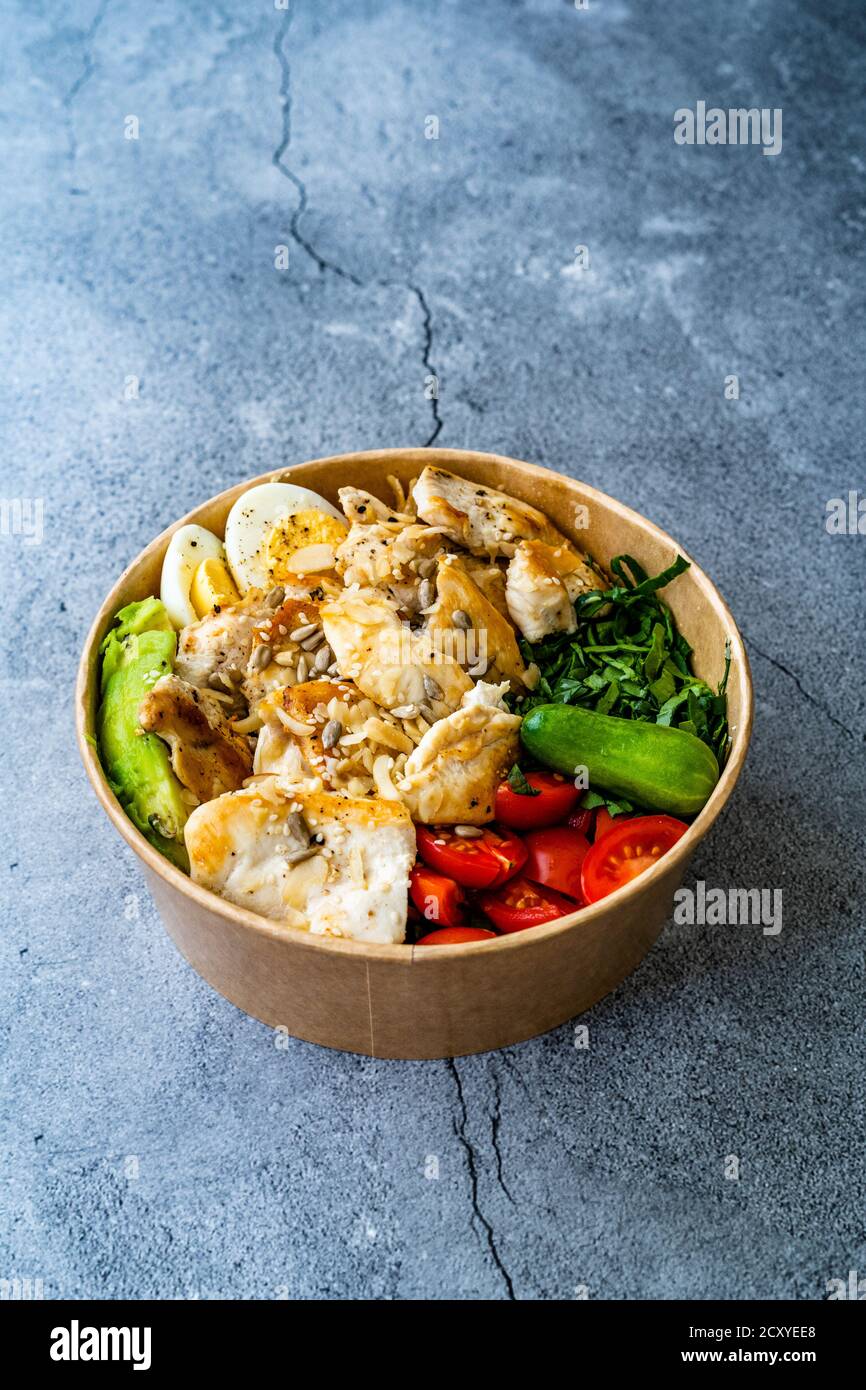 Sana Protein Fitness cibo Pollo, uovo, Spinach, avocado e cetriolo con attrezzature fitness Dumbbells per atleta in plastica Bowl. Pronto a mangiare. Foto Stock