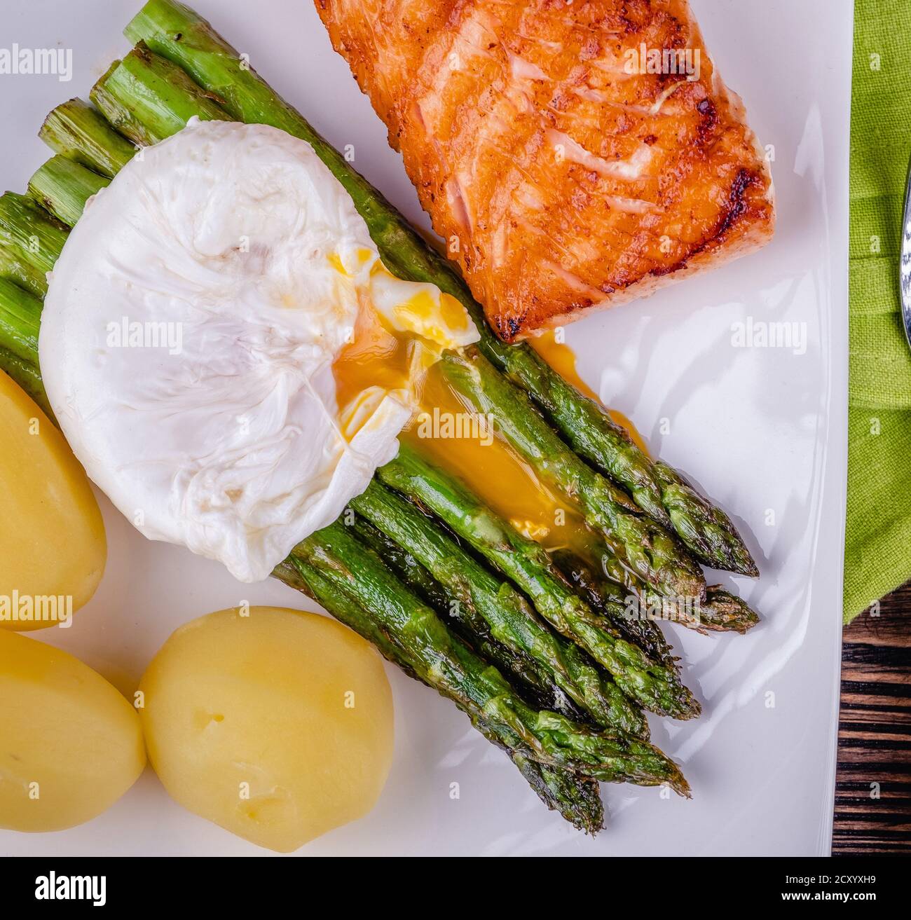 Asparagi verdi e uovo in camicia bollito su un piatto bianco. Foto Stock