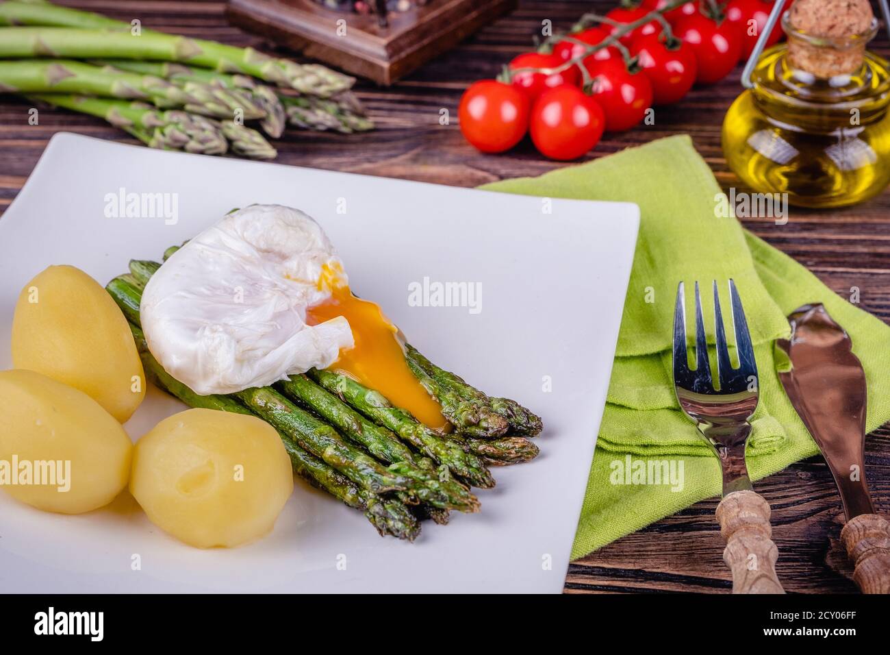 Asparagi verdi e uovo in camicia bollito su un piatto bianco. Foto Stock