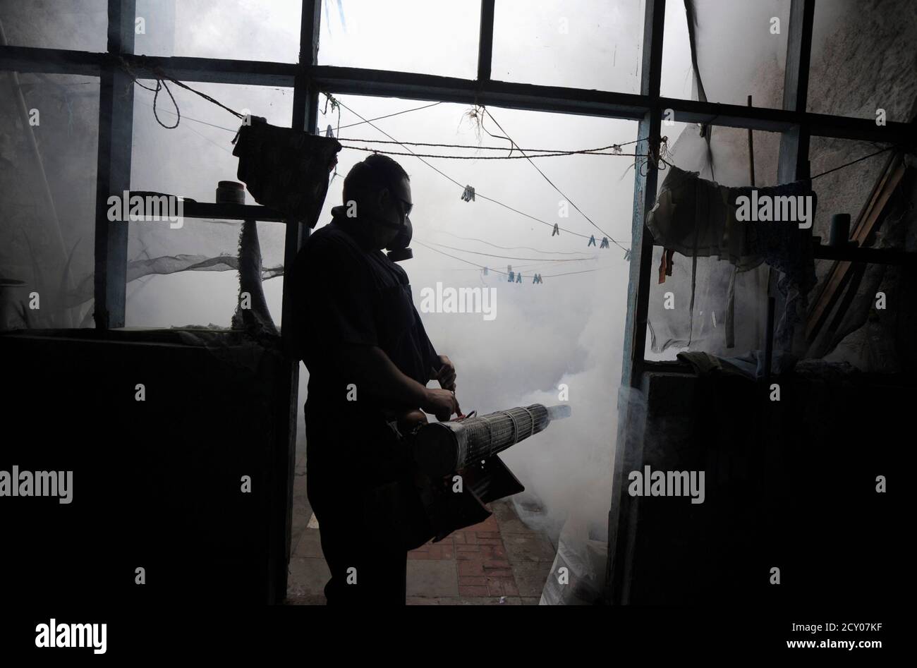 Un lavoratore governativo fumigates una casa contro le zanzare in un quartiere a Tegucigalpa 20 marzo 2012. Il governo dell'Honduras ha emesso un avvertimento di salute pubblica contro l'aumento delle incidenze della dengue causata dalle zanzare, ha riferito i media locali. REUTERS/JORGE CABRERA (HONDURAS - TAGS: POLITICA AMBIENTALE SANITARIA TPX IMMAGINI DEL GIORNO) Foto Stock