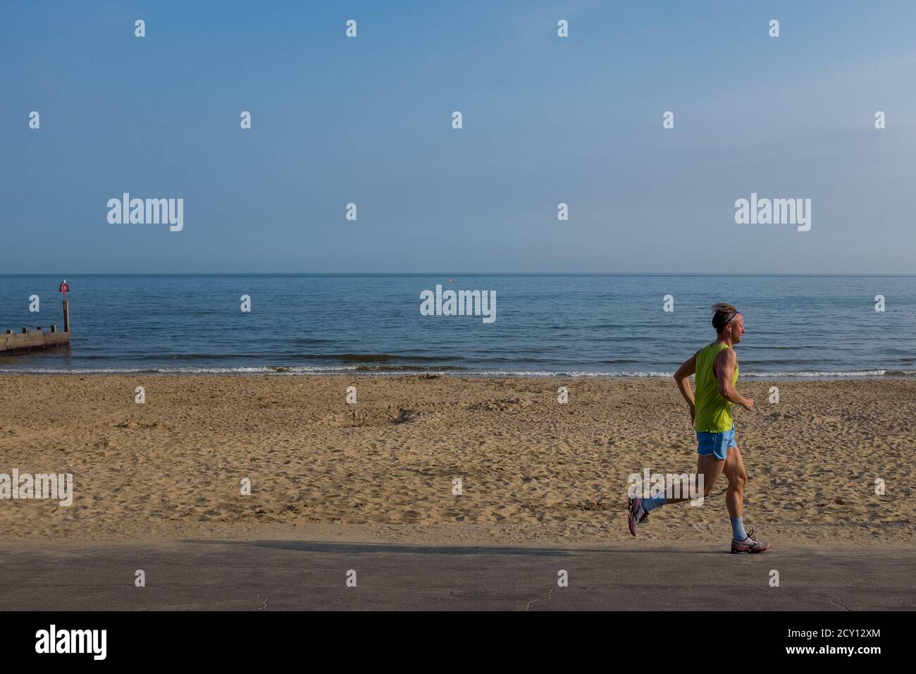 Un solitario jogger maschile sulla passeggiata in una prima serata estiva sulla spiaggia di Southbourne a Bournemouth. 06 giugno 2016. Foto: Neil Turner Foto Stock