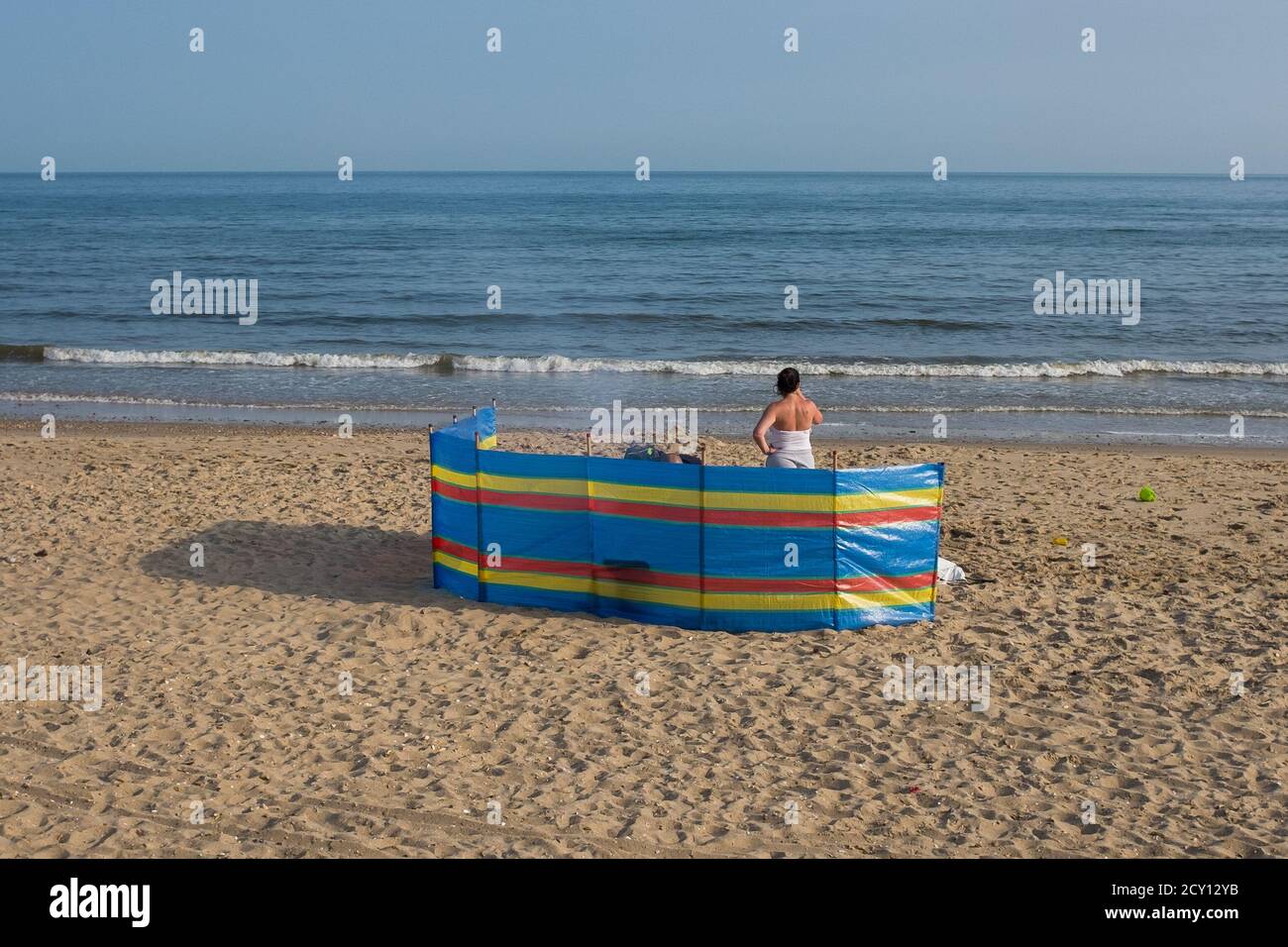 Una famiglia dietro una pausa di vento colorato in una prima serata estiva sulla spiaggia di Southbourne a Bournemouth. 06 giugno 2016. Foto: Neil Turner Foto Stock