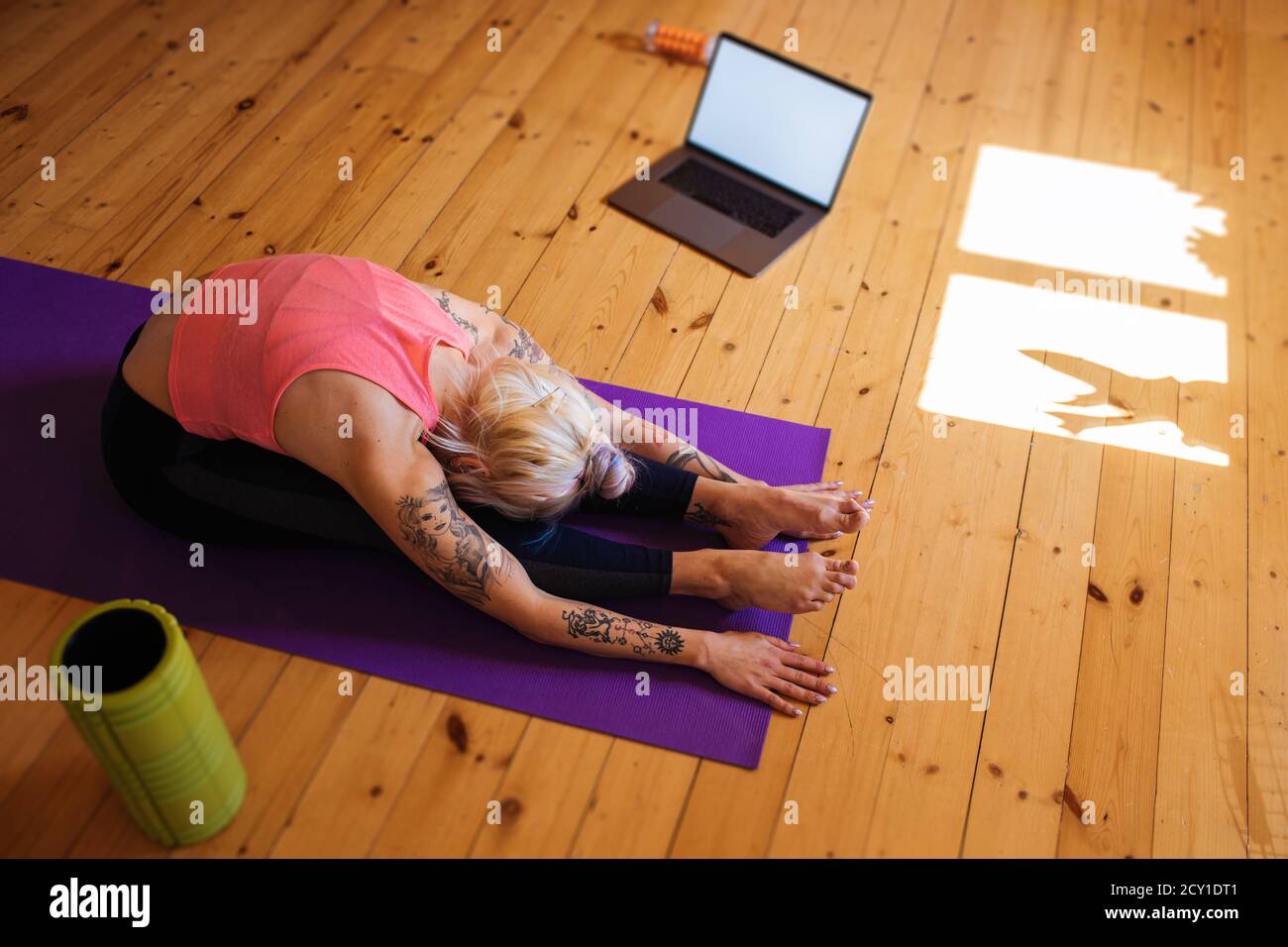 Fitness esercizio virtuale online. Donna che stretching da internet a casa. Una ragazza sportiva che si allenano. Allenamento in salotto. Foto Stock