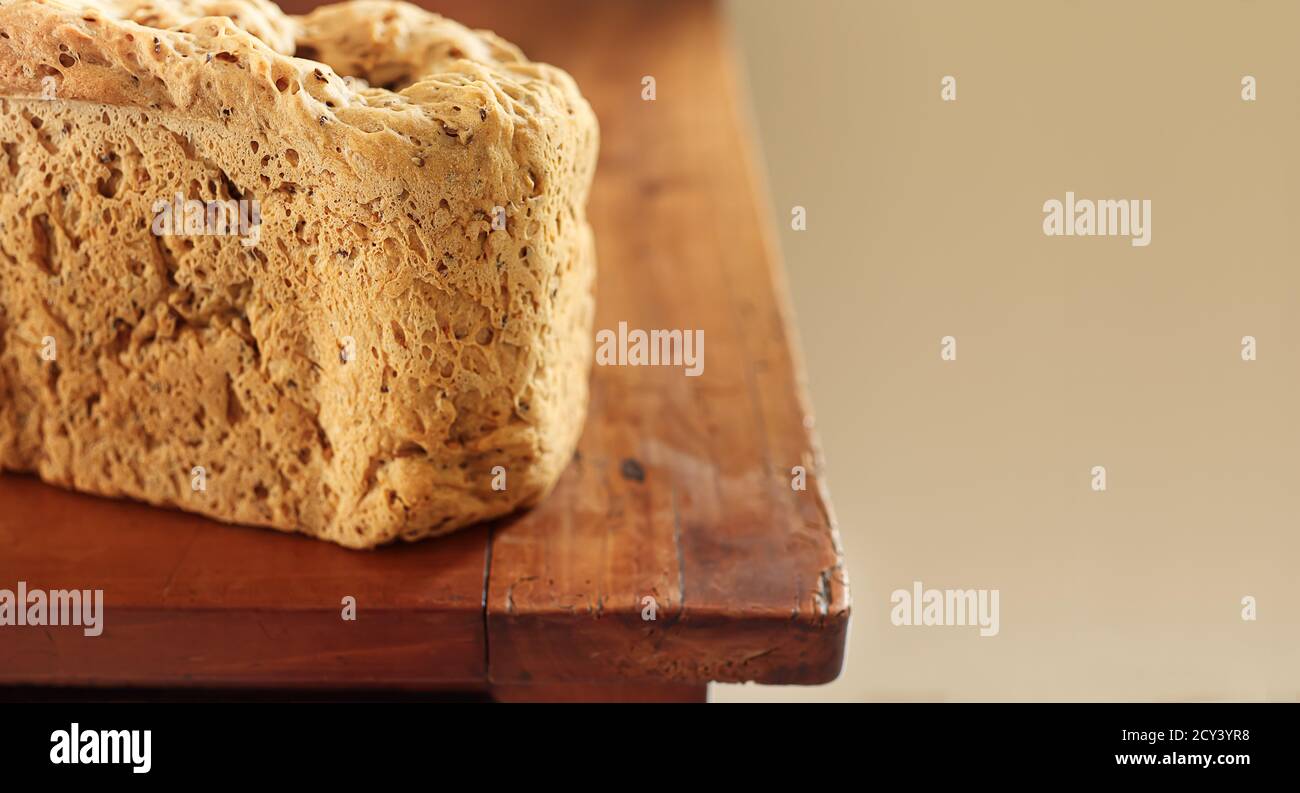 Pane sano biologico a grani multipli appena sfornato in casa su un vecchio tavolo di legno con spazio per la copia Foto Stock