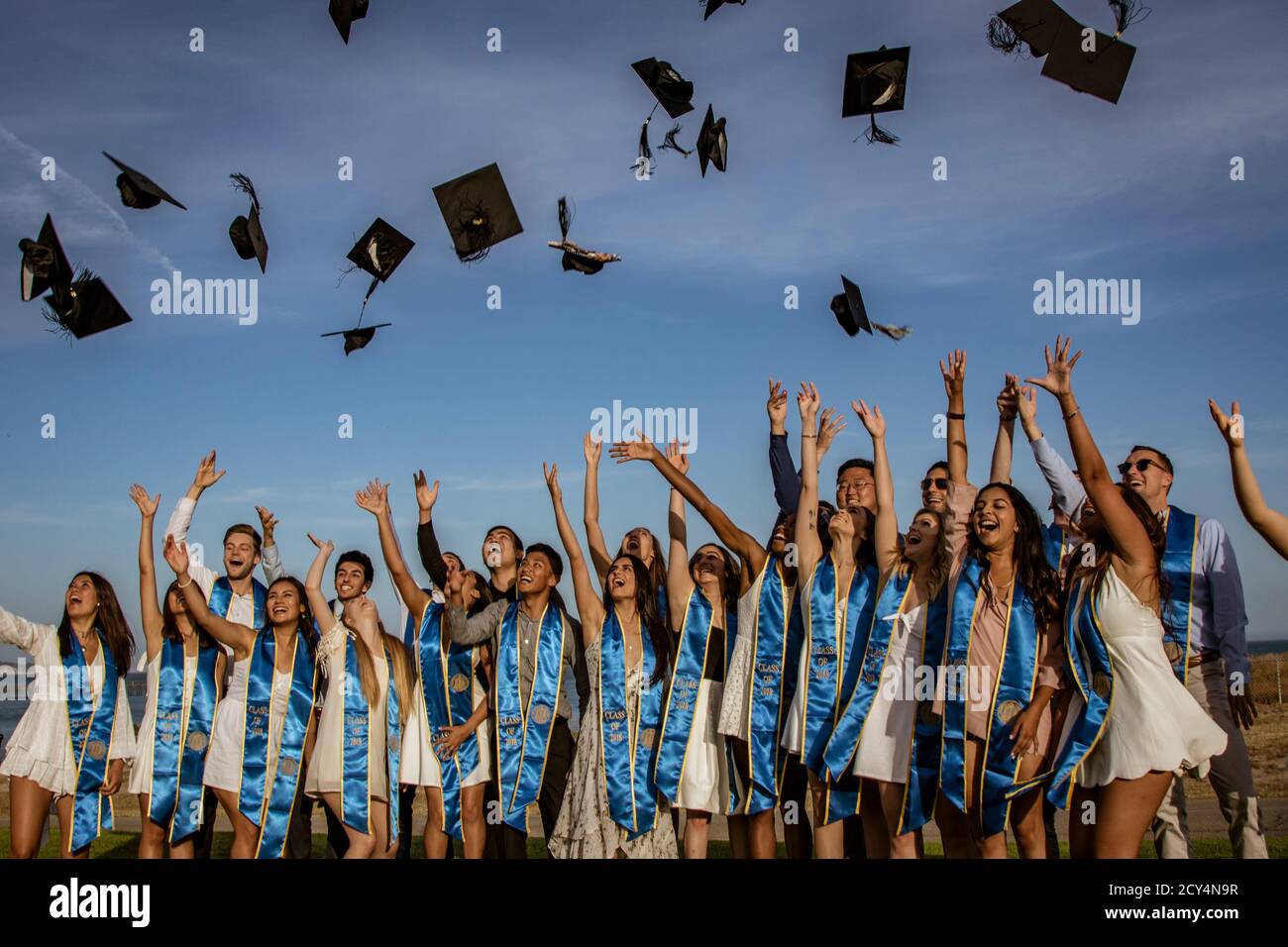 SANTA BARBARBARBRA, CALIF, USA, 8 GIUGNO 2018 - amici laureati gettano i loro tappi di graduazione nell'aria Foto Stock