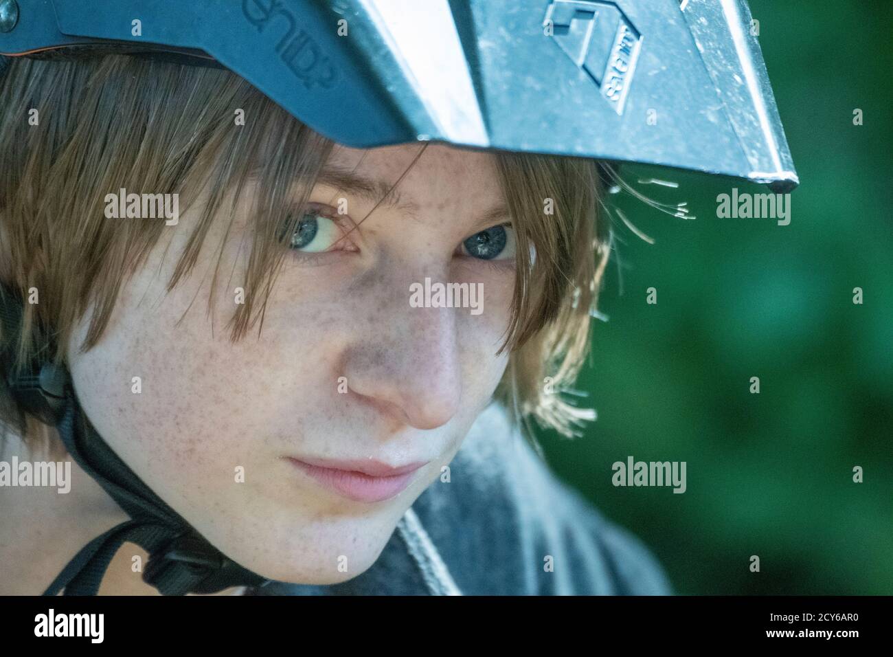 Ragazzo con casco per mountain bike che guarda la macchina fotografica Foto Stock