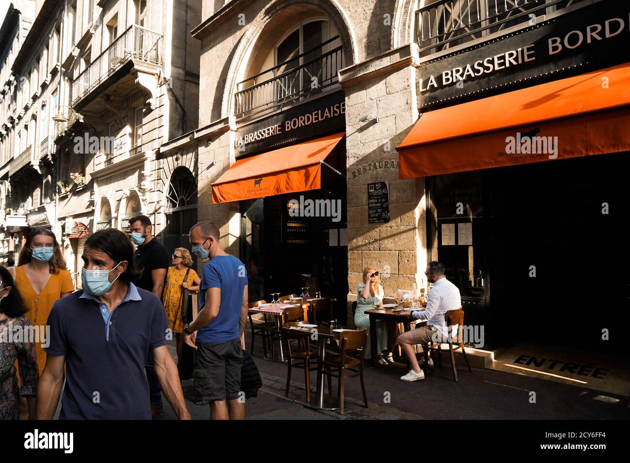 Bordeaux - 08/27/2020: Coppia senza maschera di protezione godendo di una cena sui tavoli all'aperto mentre la gente passa da Foto Stock