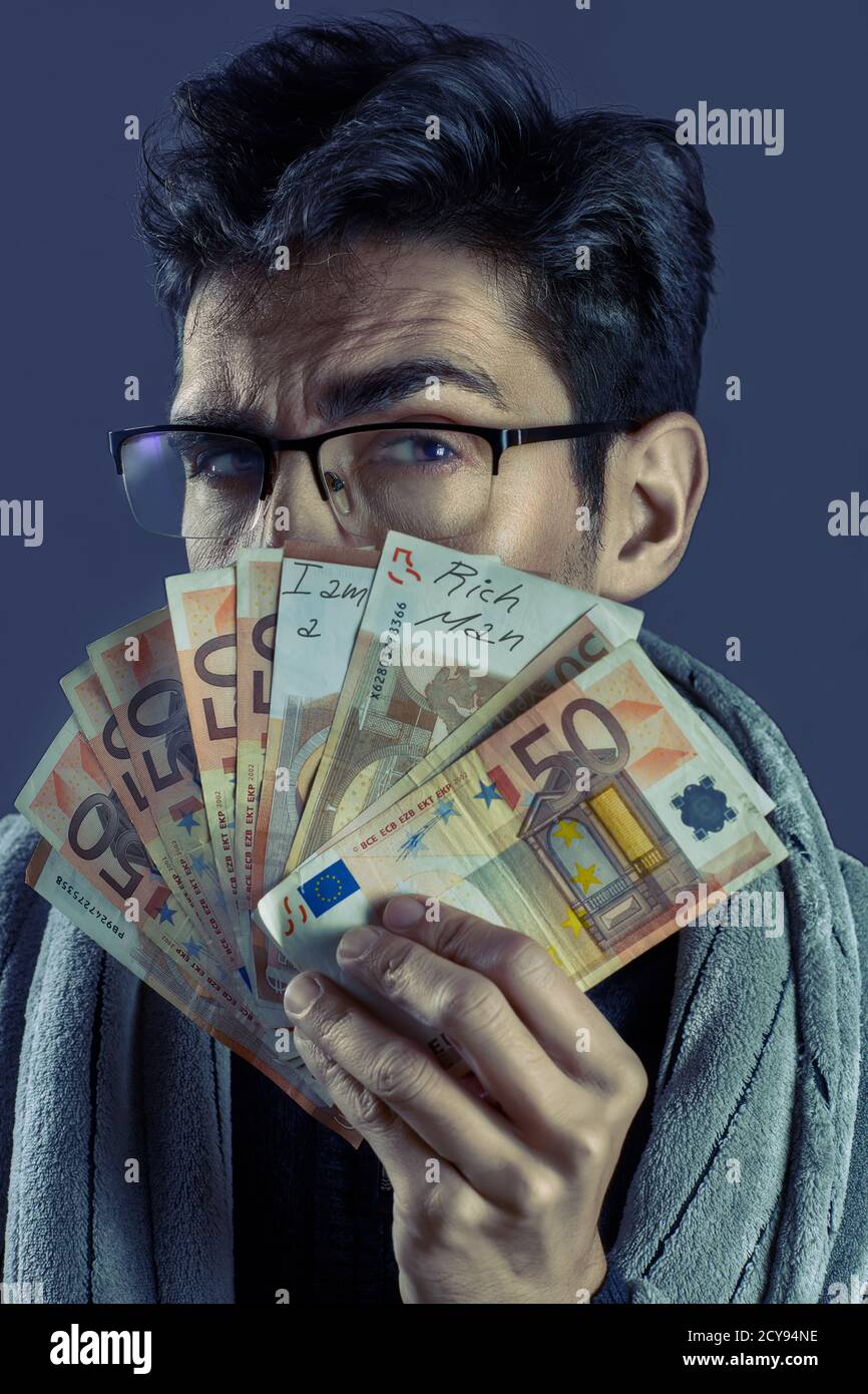 Uomo ricco con un ventilatore su 50 euro fatture e indossare occhiali Foto Stock