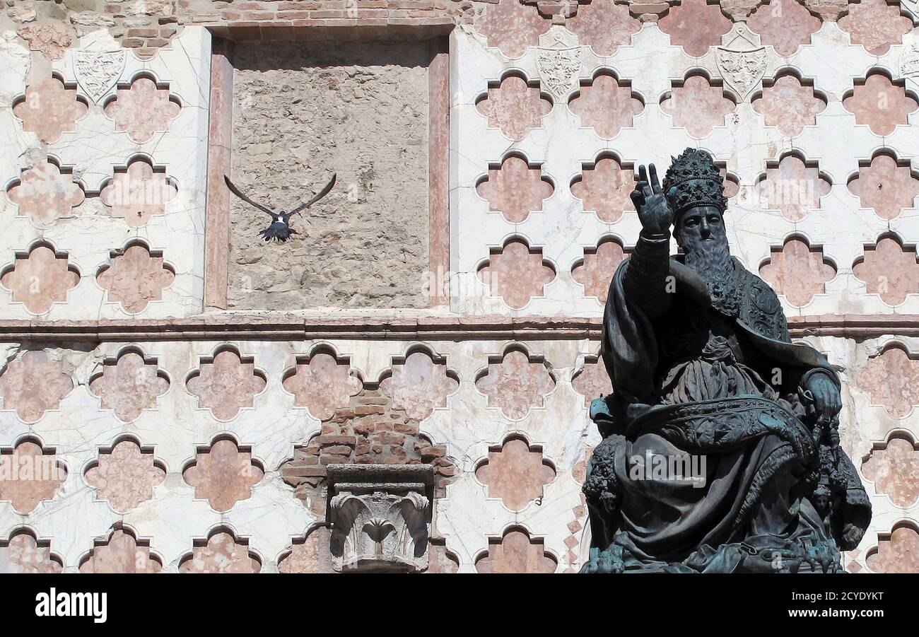 A pigeon flies near the bronze statue of Pope Giulio III, in front of the Cathedral of San Lorenzo, in downtown Perugia October 1, 2011. REUTERS/Alessandro Bianchi (ITALY - Tags: ANIMALS SOCIETY TRAVEL RELIGION) Foto Stock