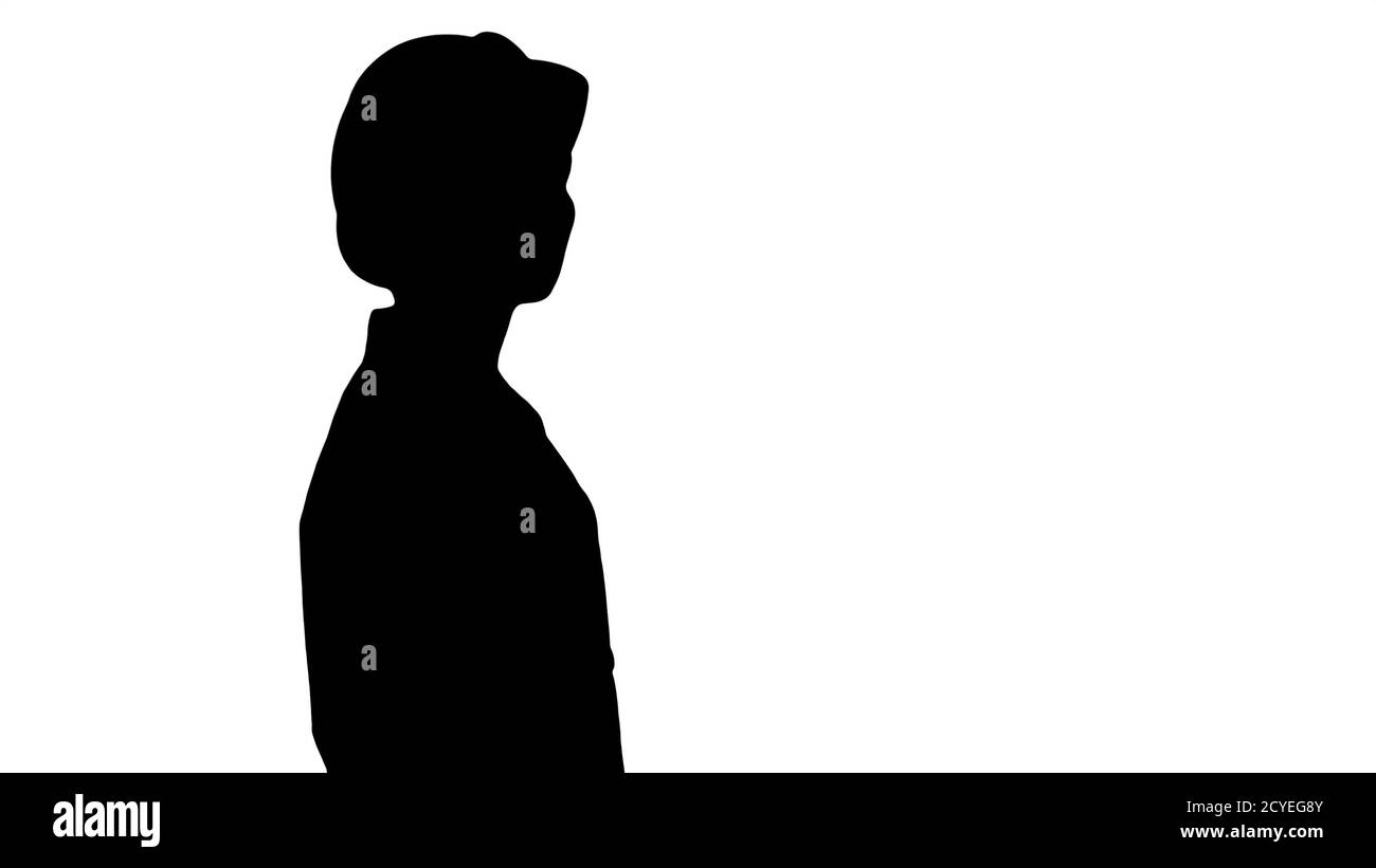 Silhouette giovane donna in elmetto che cammina e guarda intorno. Foto Stock