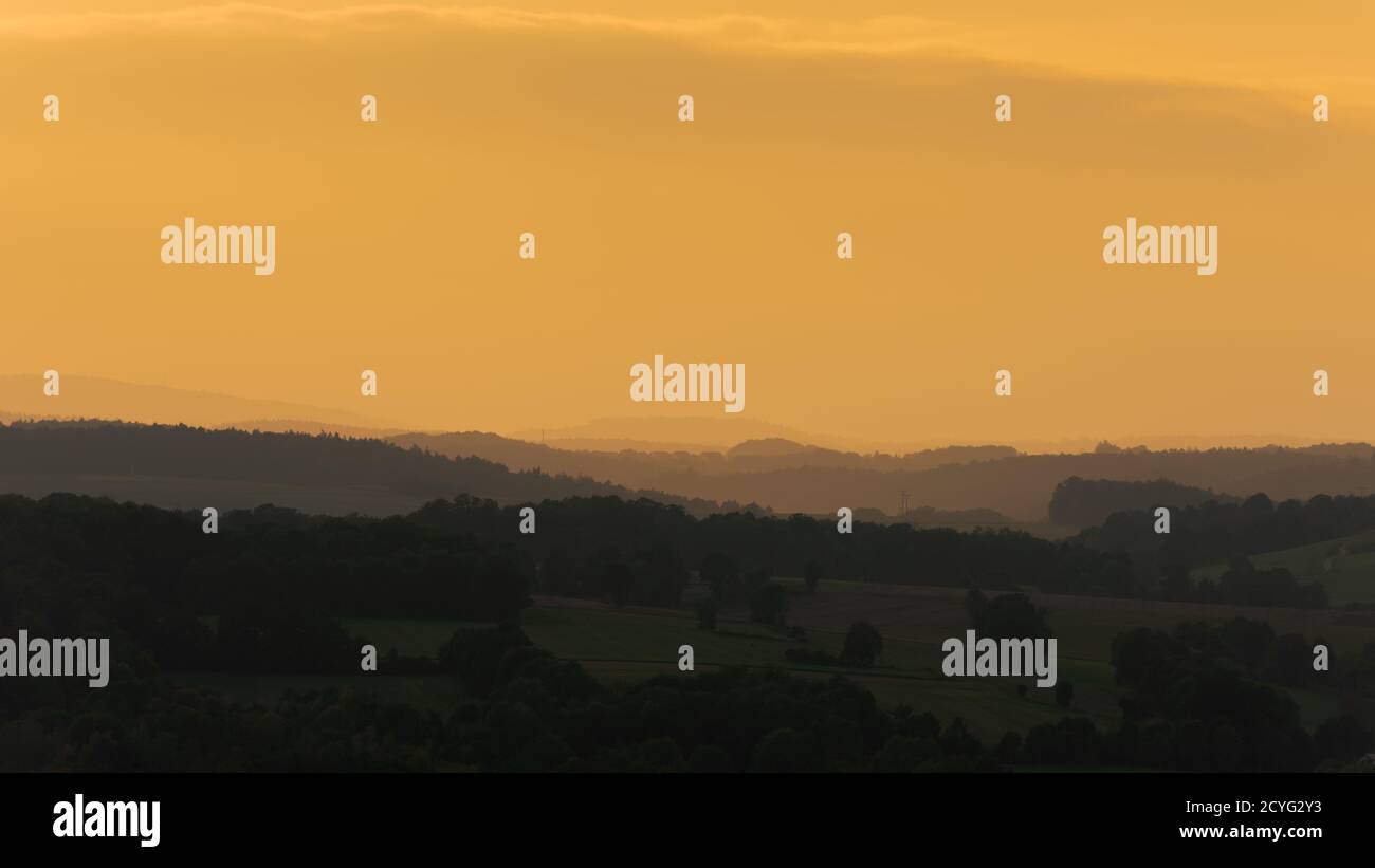 Densa foschia gialla sul paesaggio con colline e alberi in Autunno vicino a Ratisbona in Germania Foto Stock