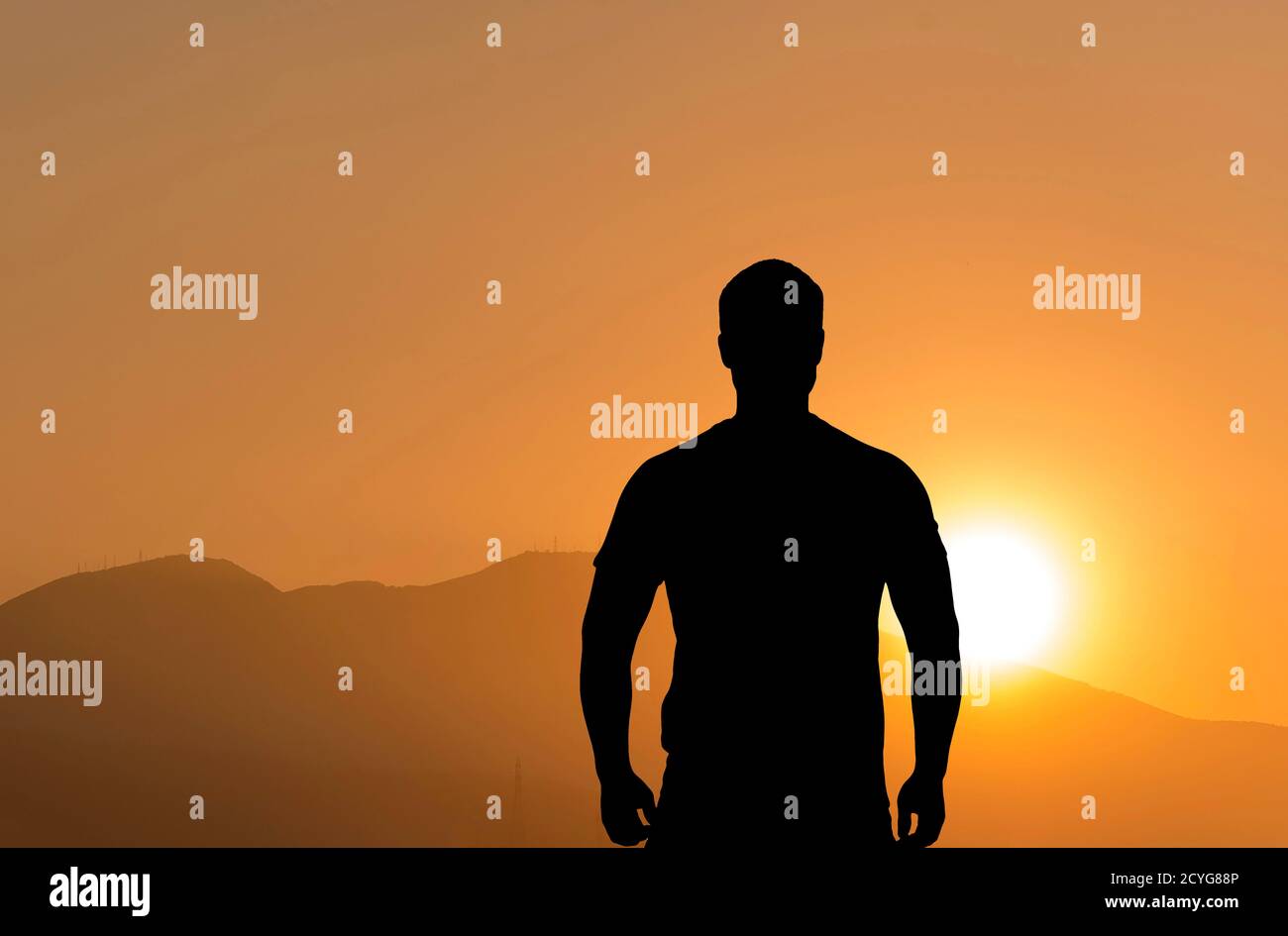 Silhouette di un uomo in piedi di fronte alle montagne durante bellissimo tramonto Foto Stock