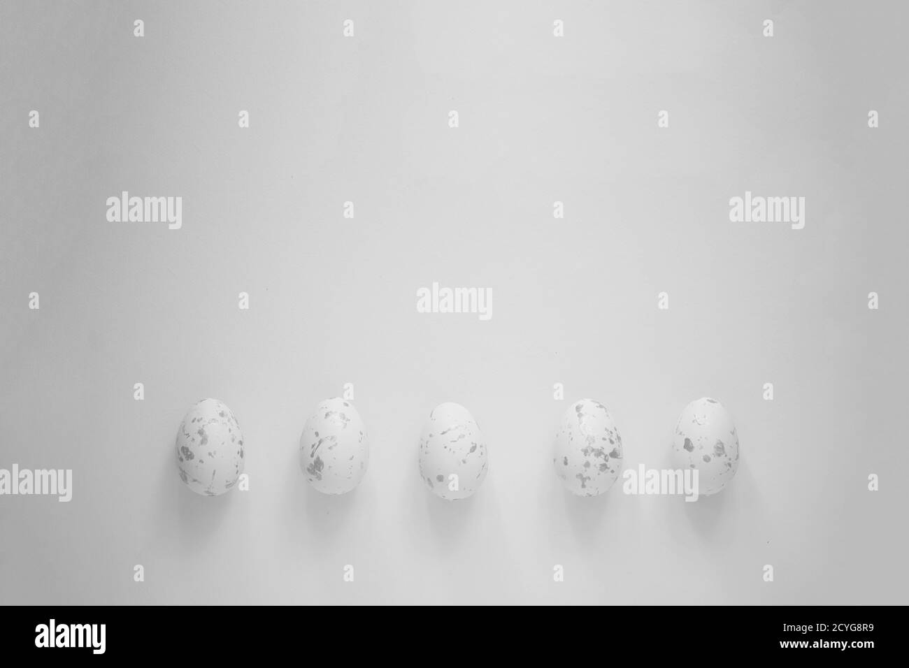 Uova di Pasqua che si stendano in fila sullo sfondo piano sfondo grigio chiaro minimo Foto Stock