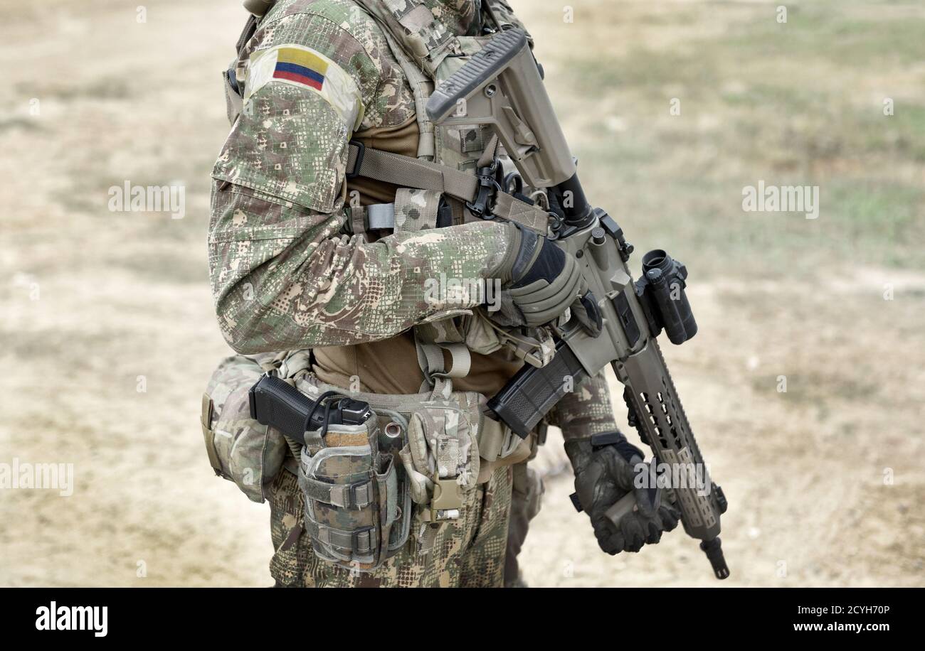 Soldato con fucile d'assalto e bandiera della Colombia su uniforme militare. Collage. Foto Stock