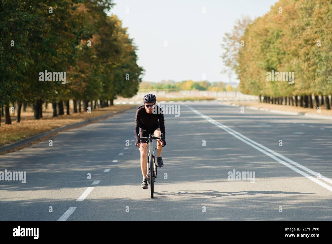 Ciclista della strada che si esercita su una bici della ghiaia. Allenamento in bicicletta all'aperto, bicicletta e sportivo dall'aspetto moderno, stile di vita attivo Foto Stock