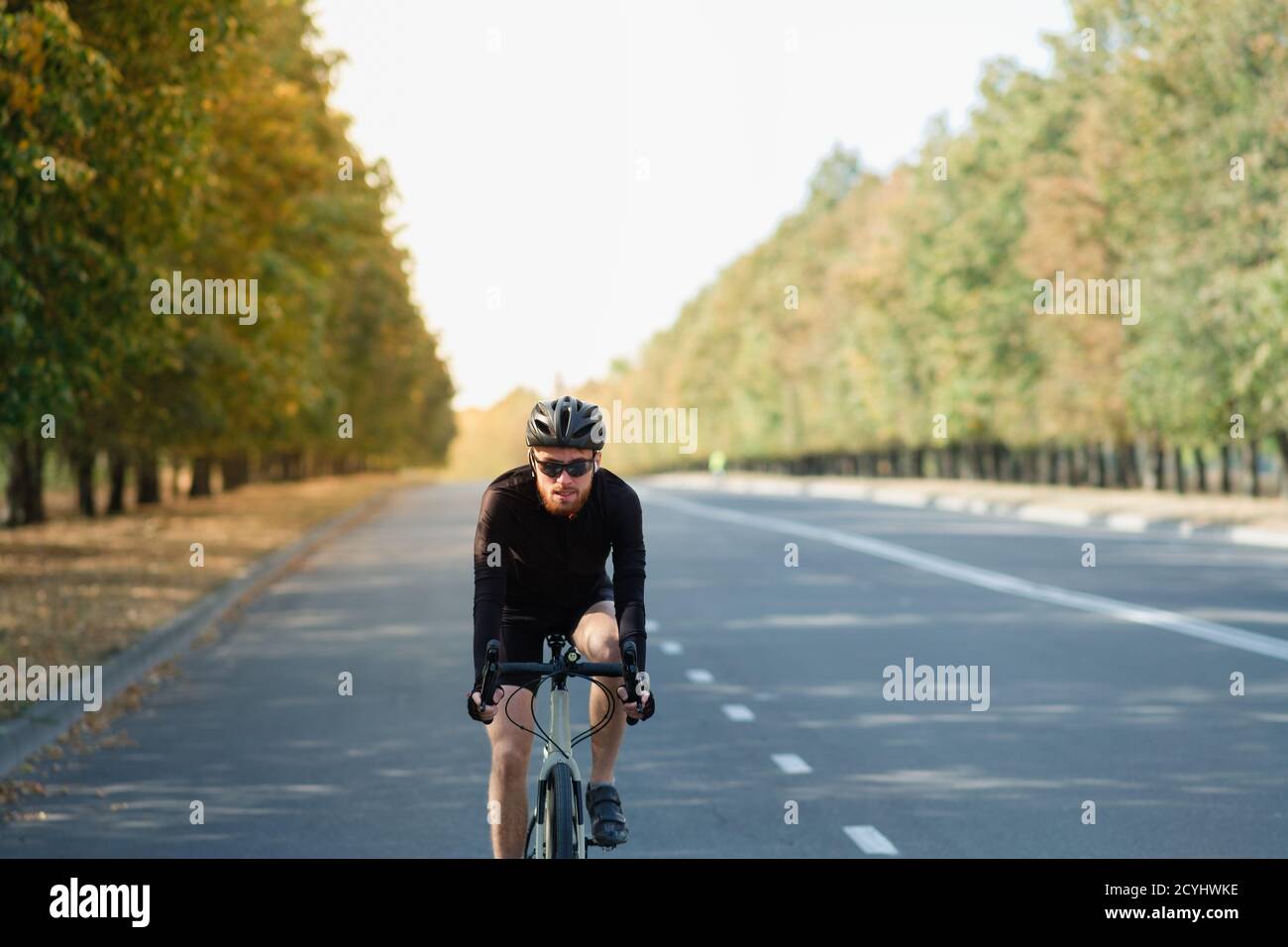 Ciclista della strada che si esercita su una bici della ghiaia. Allenamento in bicicletta all'aperto, bicicletta e sportivo dall'aspetto moderno, stile di vita felice e attivo Foto Stock