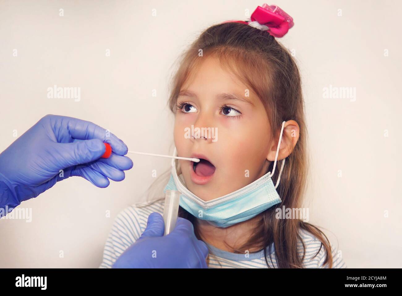 Medico che fa Coronavirus Test per la ragazza paziente. Test del DNA. Raccolta del muco dalla gola per la ricerca in laboratorio. Prelievo di un campione di saliva Foto Stock