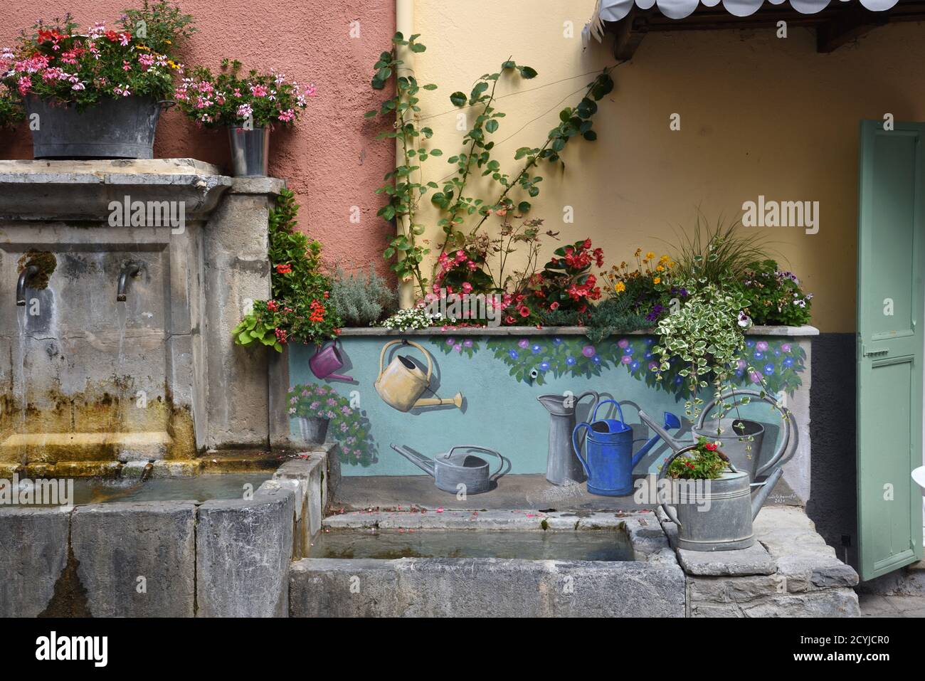 Trompe l'Oeil decorazione o dipinto Fontana Village con Antique o. Lattine d'annaffiatura in metallo antico Colmars-les-Alpes Alpes-de-Haute-Provence Provence Provence France Foto Stock