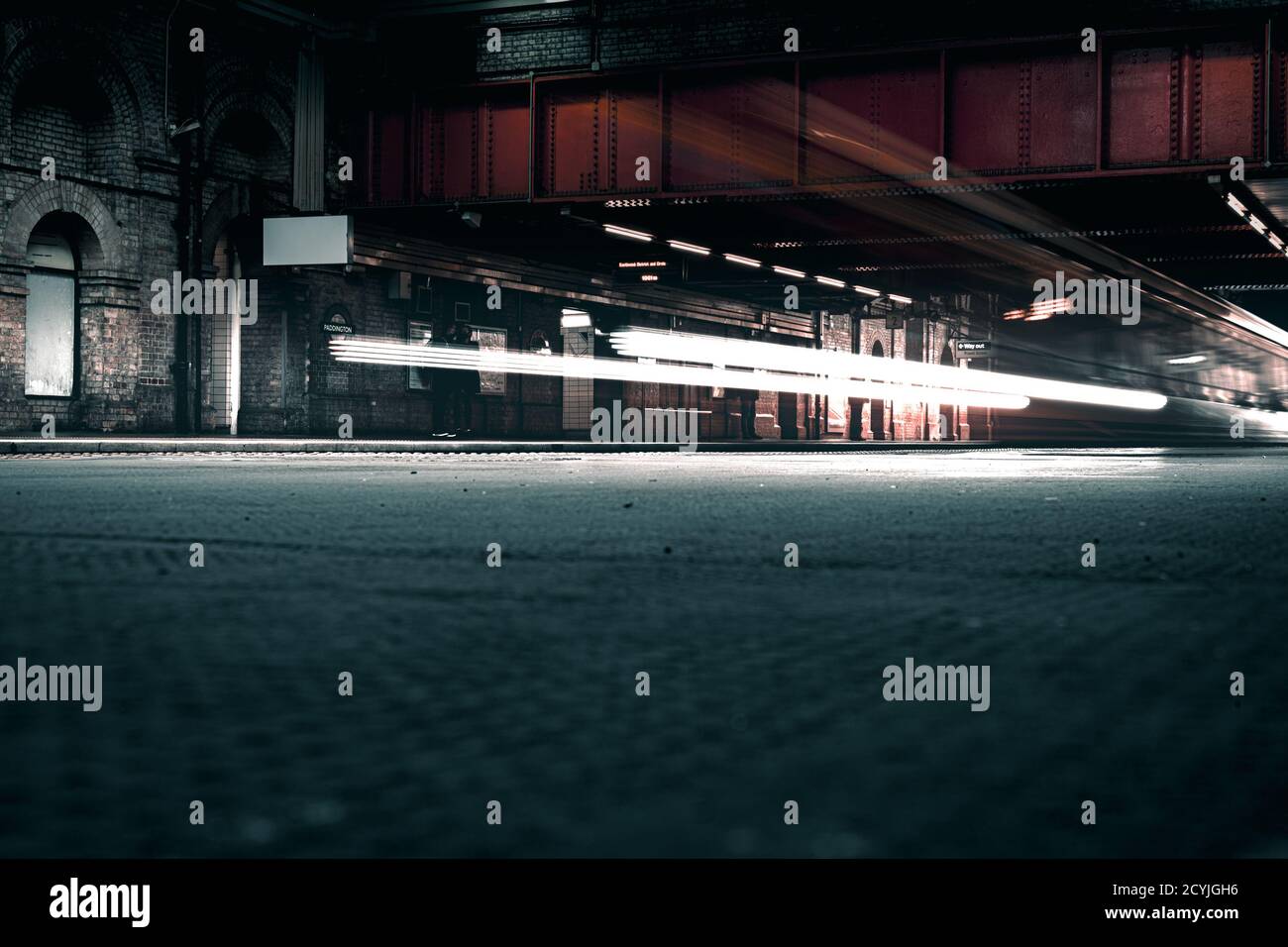 Riprese cinematografiche a lunga esposizione della rete ferroviaria sotterranea in Londra in una stazione all'aperto con luci luminose Foto Stock