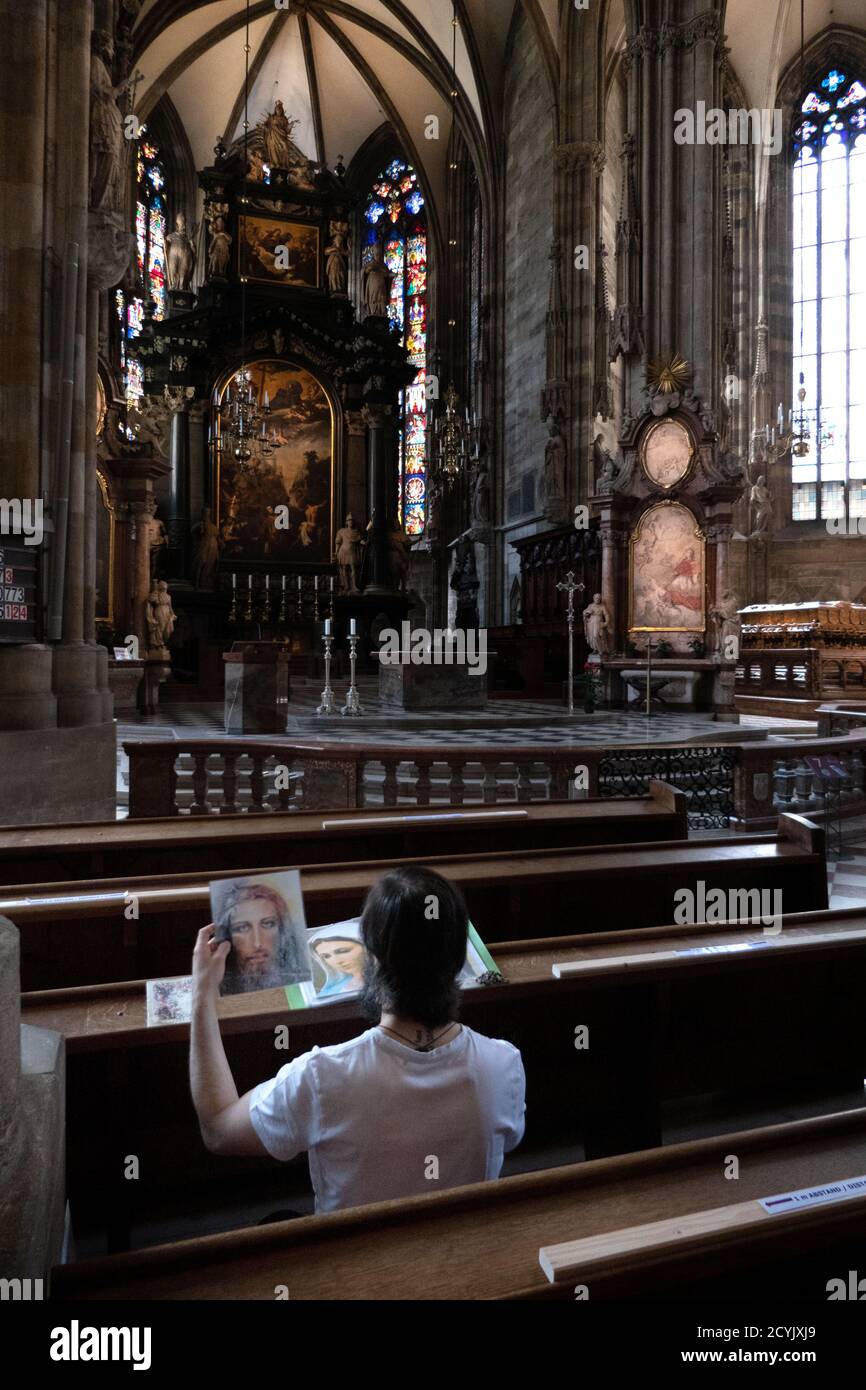 Lone uomo che prega all'interno della cattedrale di Santo Stefano o Stephansdom a Vienna, Austria, Europa. Persone e religione nella chiesa cattolica di Vienna Foto Stock