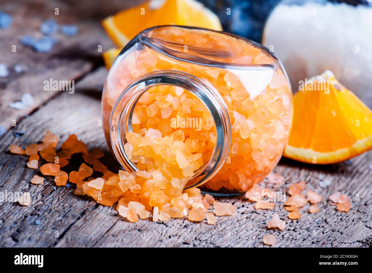 Sali da bagno arancioni in un vaso di vetro su sfondo di legno vintage, fuoco selettivo Foto Stock