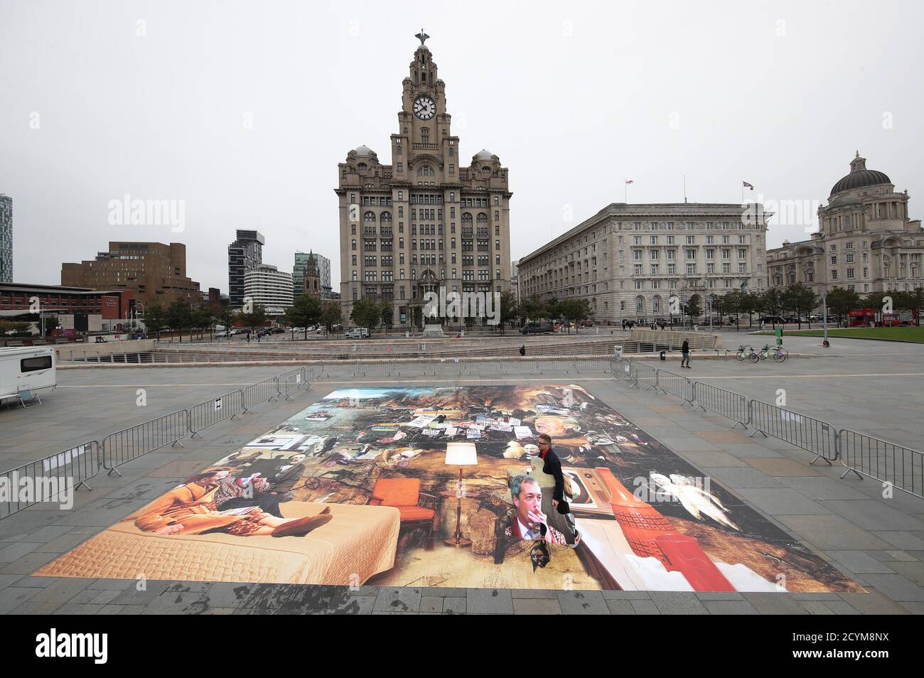 L'artista Cold War Steve con il suo nuovo pezzo d'arte, Trumpscape, fuori dal Liver Building a Liverpool. Foto Stock