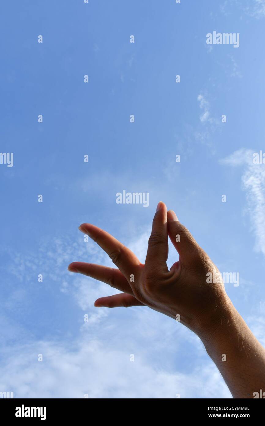 Man mano posizione, cercare di toccare il cielo Foto Stock