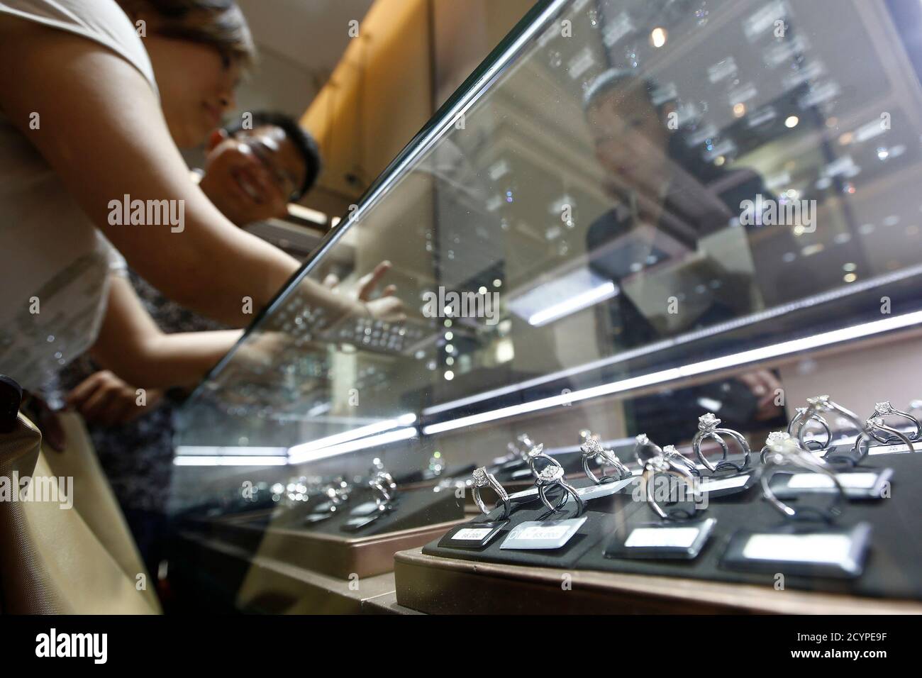 Una coppia seleziona anelli di diamante in un negozio Chow Tai Fook a Shanghai 16 settembre 2013. Secondo i dati forniti dalla società di ricerca di mercato Euromonitor, il mercato cinese dei diamanti, ora il secondo più grande al mondo dopo gli Stati Uniti, è più che triplicato a 22.8 miliardi di dollari negli ultimi cinque anni, costantemente triplicato rispetto all'oro e ben oltre il tasso di crescita dei 465 miliardi di yuan cinesi (76 miliardi di dollari) settore della gioielleria. Foto scattata il 16 settembre 2013. Per abbinare la funzione CINA-DIAMANTI/ REUTERS/Aly Song (CINA - Tag: PRODOTTI COMMERCIALI) Foto Stock