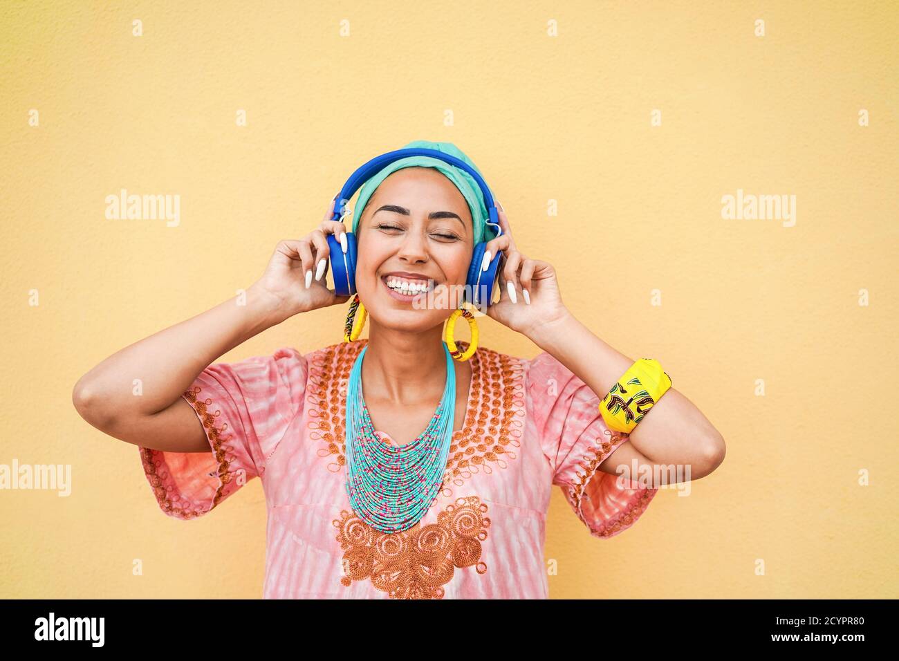 Giovane donna africana che ascolta musica con le cuffie - Focus on faccia Foto Stock