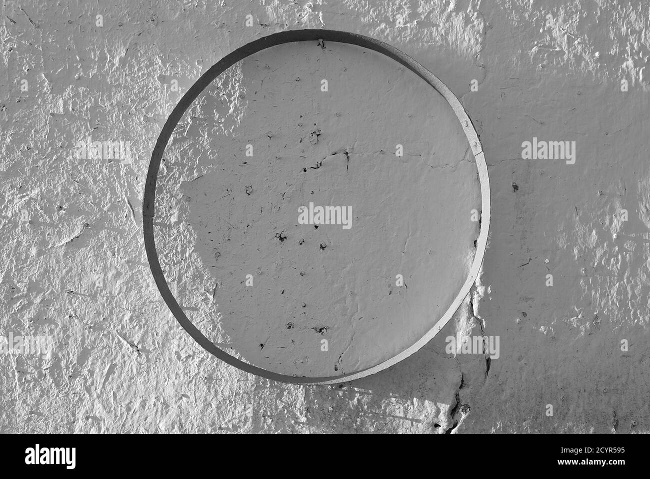 primo piano bianco e nero del cerchio della ruota dentata su a. parete Foto Stock