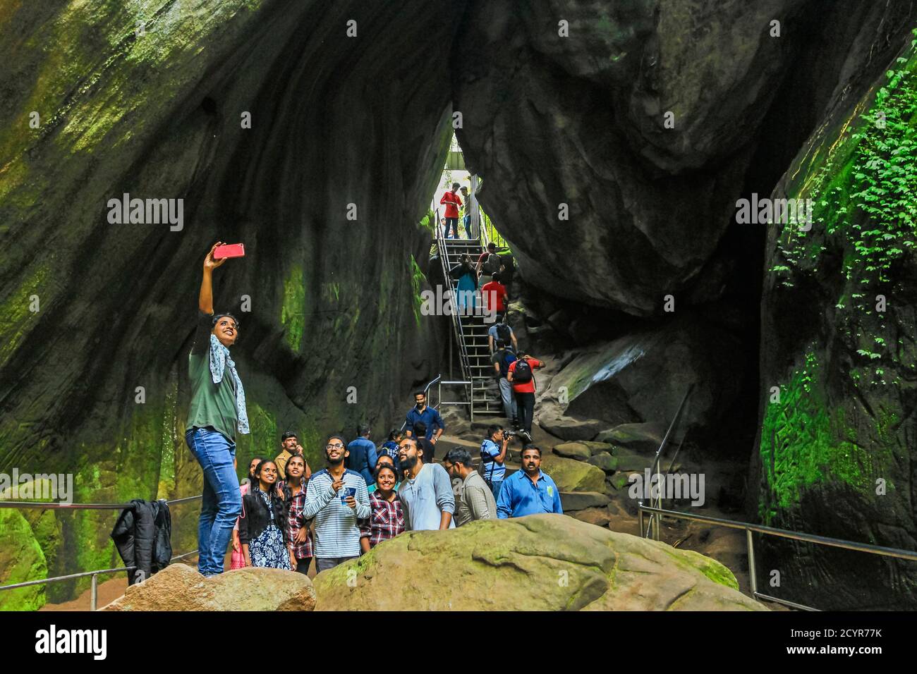 I visitatori possono scattare una foto "felfie" per telefono durante un viaggio alle storiche grotte di Edakkal e sculture neolitiche; Edakkal, Ambukutty Mala, Wayanad, Kerala, India Foto Stock