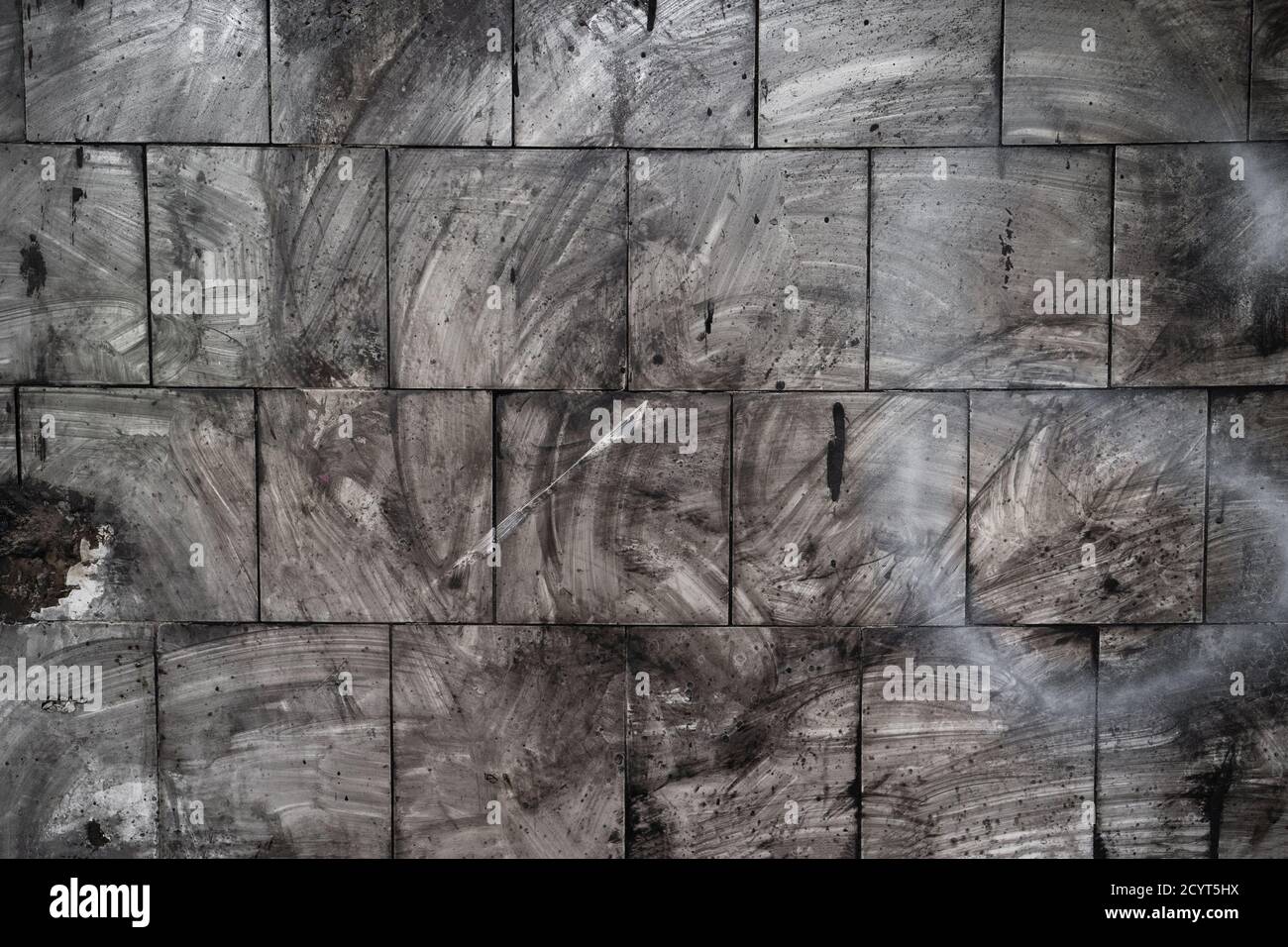 Macchie scure sulla parete della piastrella dopo il fuoco. Sfondo grunge astratto. Foto di alta qualità Foto Stock