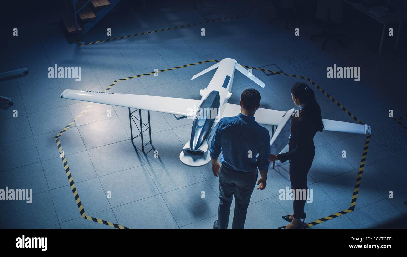 Il team di ingegneri aerospaziali industriali lavora sul concetto di veicoli aerei senza equipaggio. I progettisti lavorano su drone senza pilota. Struttura industriale con aeromobili Foto Stock