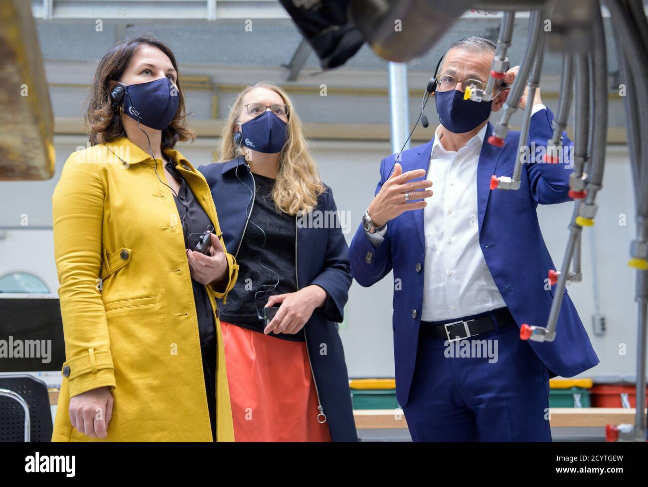 Ludwigsfelde, Germania. 02 ottobre 2020. Annalena Baerbock (l), Presidente Nazionale di Bündnis 90/Die Grünen, e Andre Sinanian, Presidente e Amministratore Delegato di MTU Maintenance Berlin Brandenburg, parlano durante una visita della struttura. Al centro c'è Katharina Dröge, portavoce della politica economica dei Verdi. MTU è un'azienda specializzata nella manutenzione di turbine industriali a gas e motori aerodinamici. Credit: Soeren Stache/dpa-Zentralbild/dpa/Alamy Live News Foto Stock